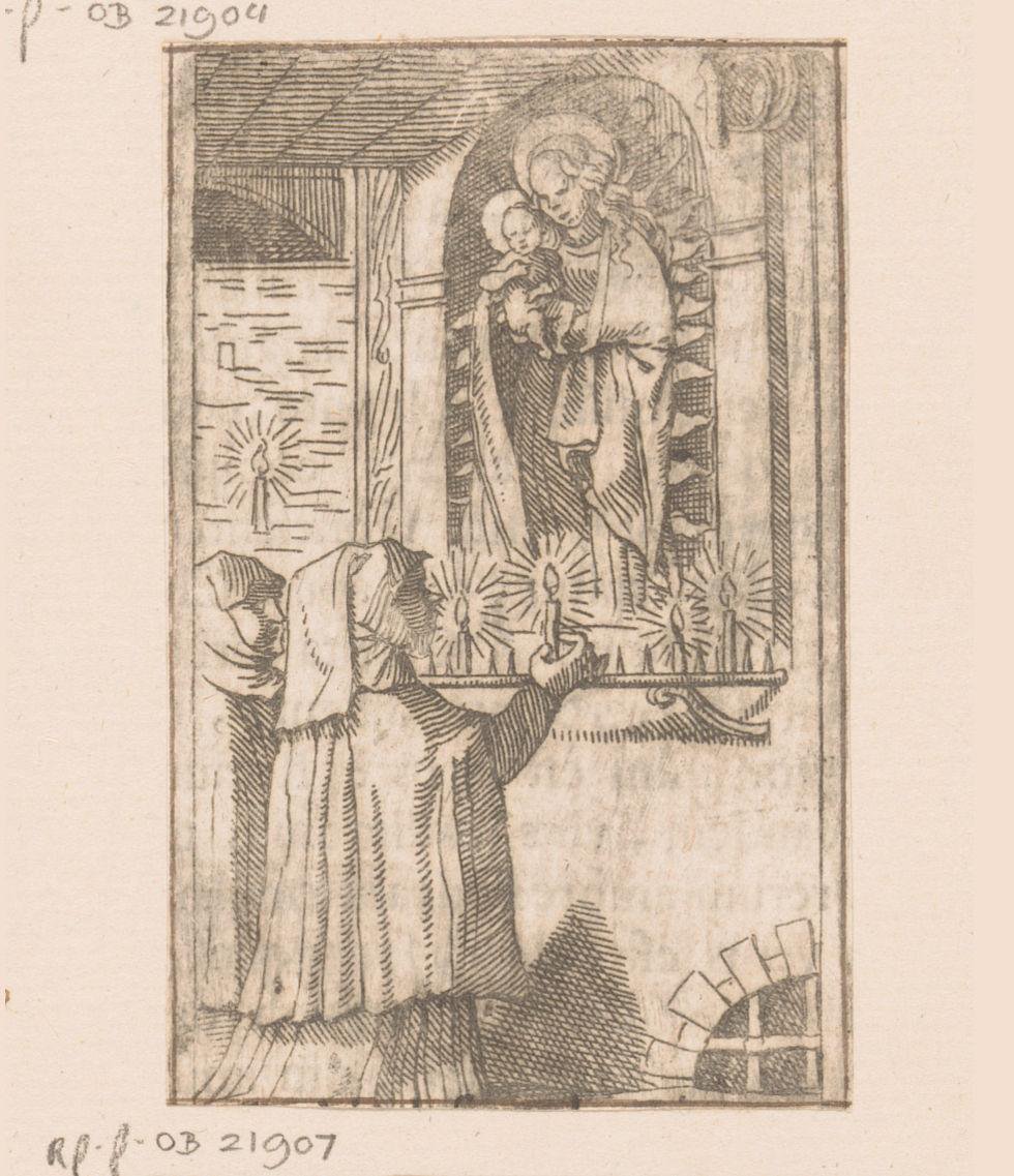 Twee vrouwen steken kaarsen aan voor een beeld van de Madonna