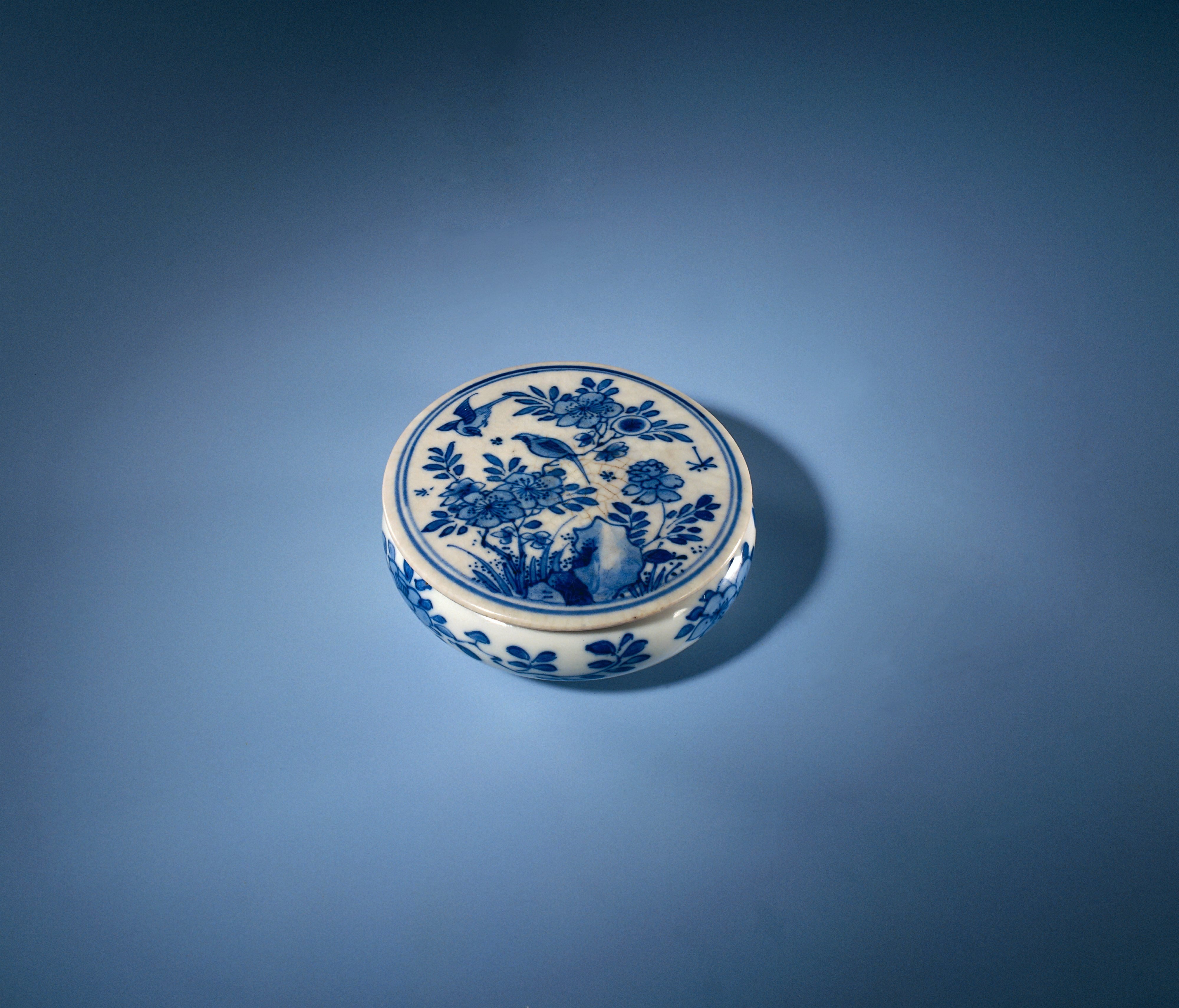 Round box with flowering plans, flower sprays and an erotic scene