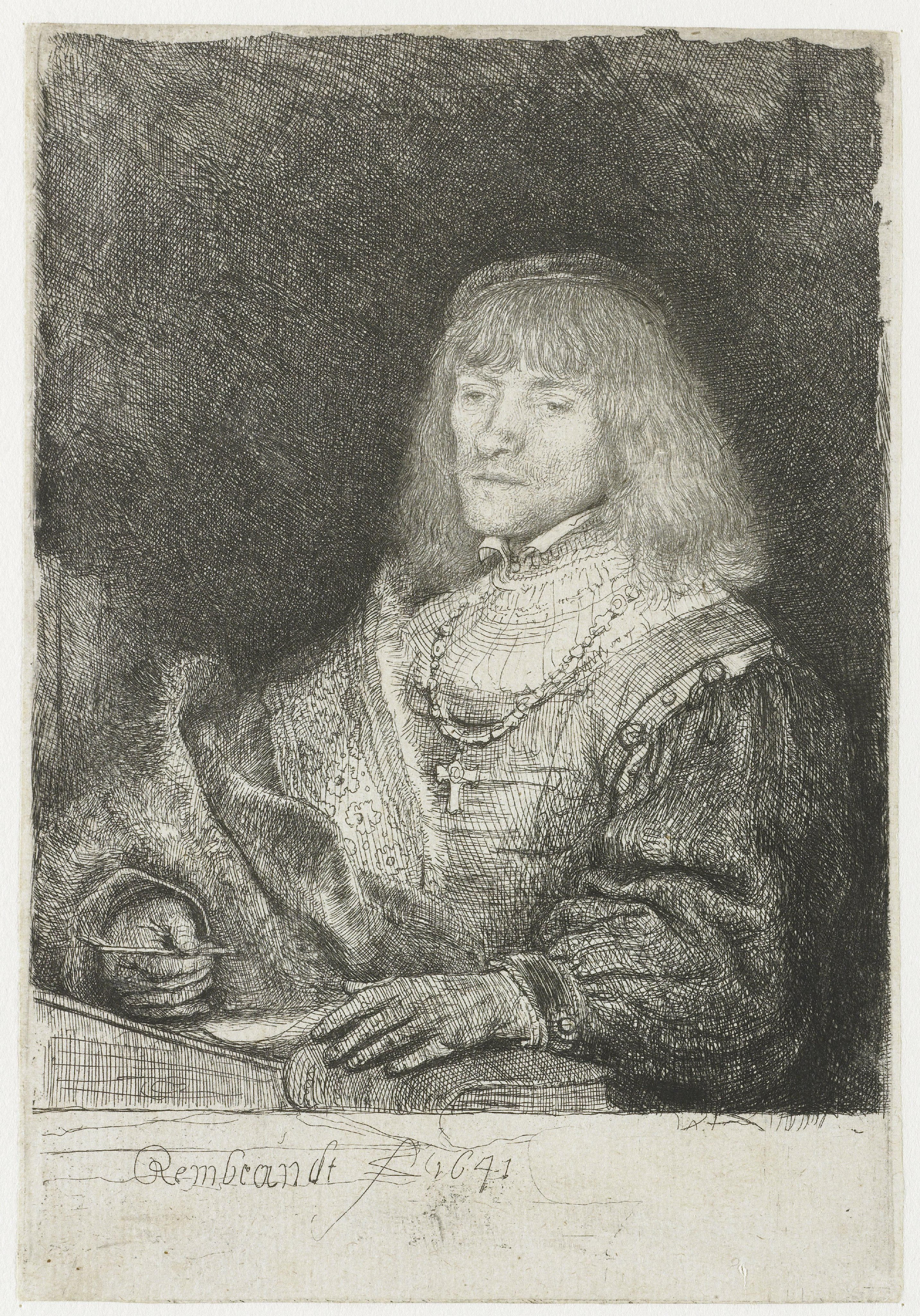 Man at a desk wearing a cross and chain