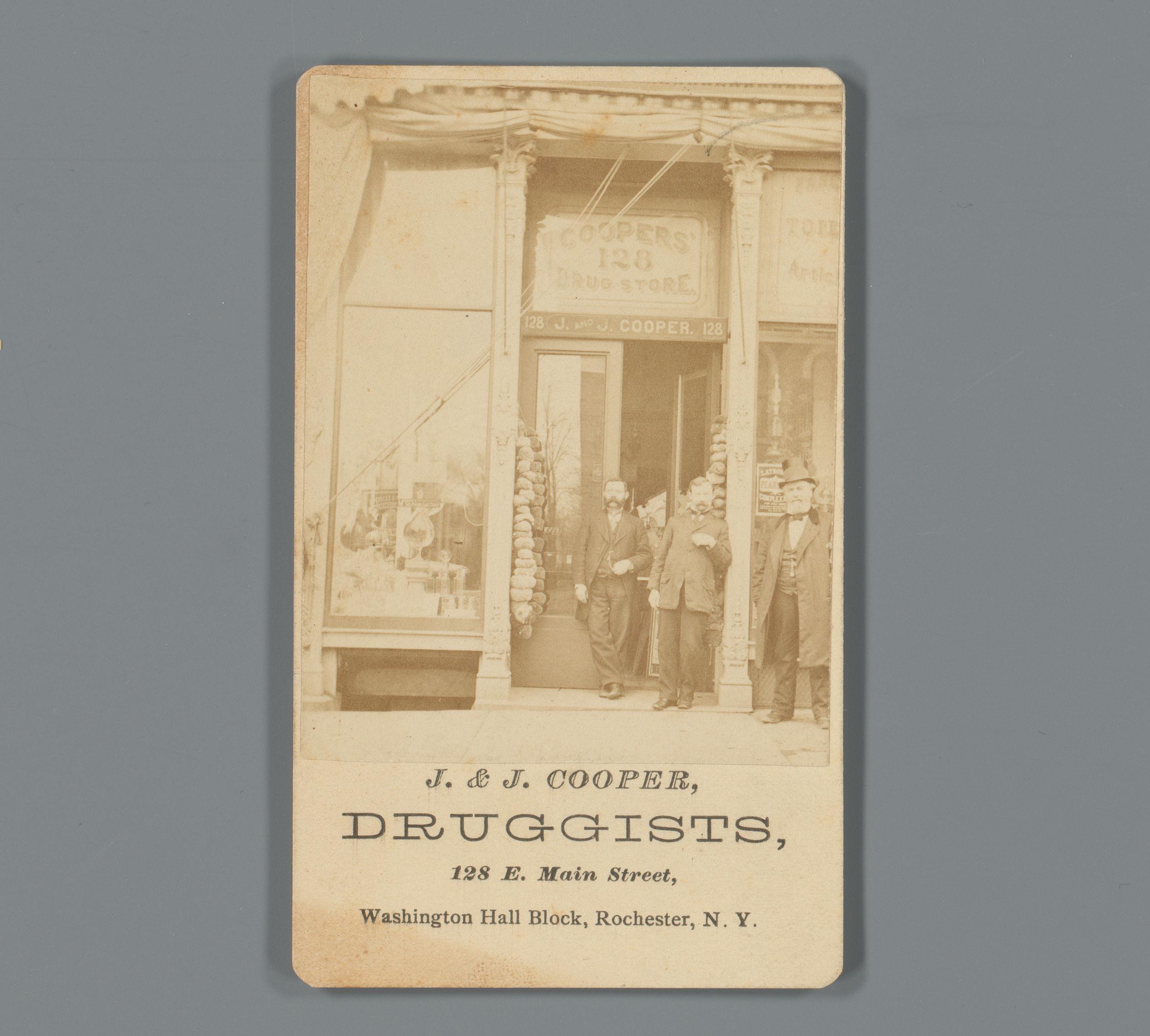 Gezicht op de etalage van drogist J. & J. Cooper met personeel in Rochester, New York