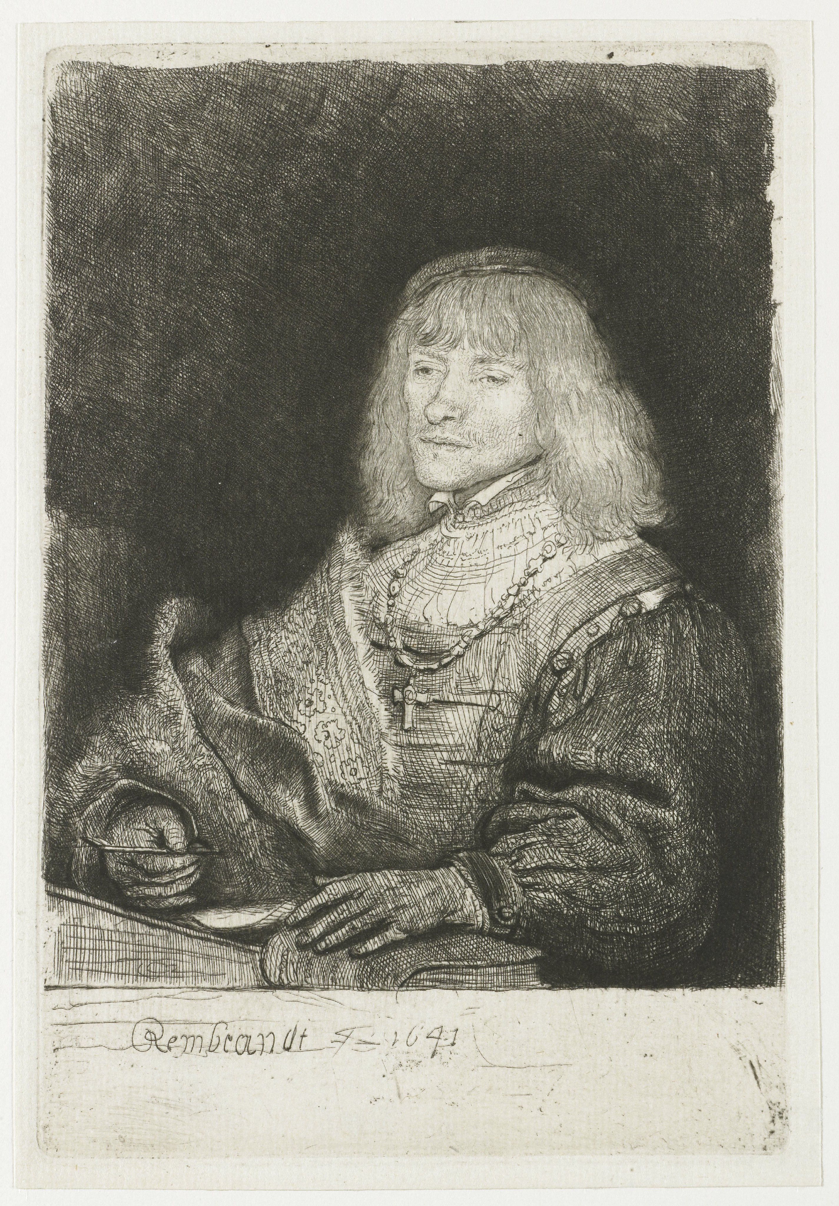 Man at a desk wearing a cross and chain
