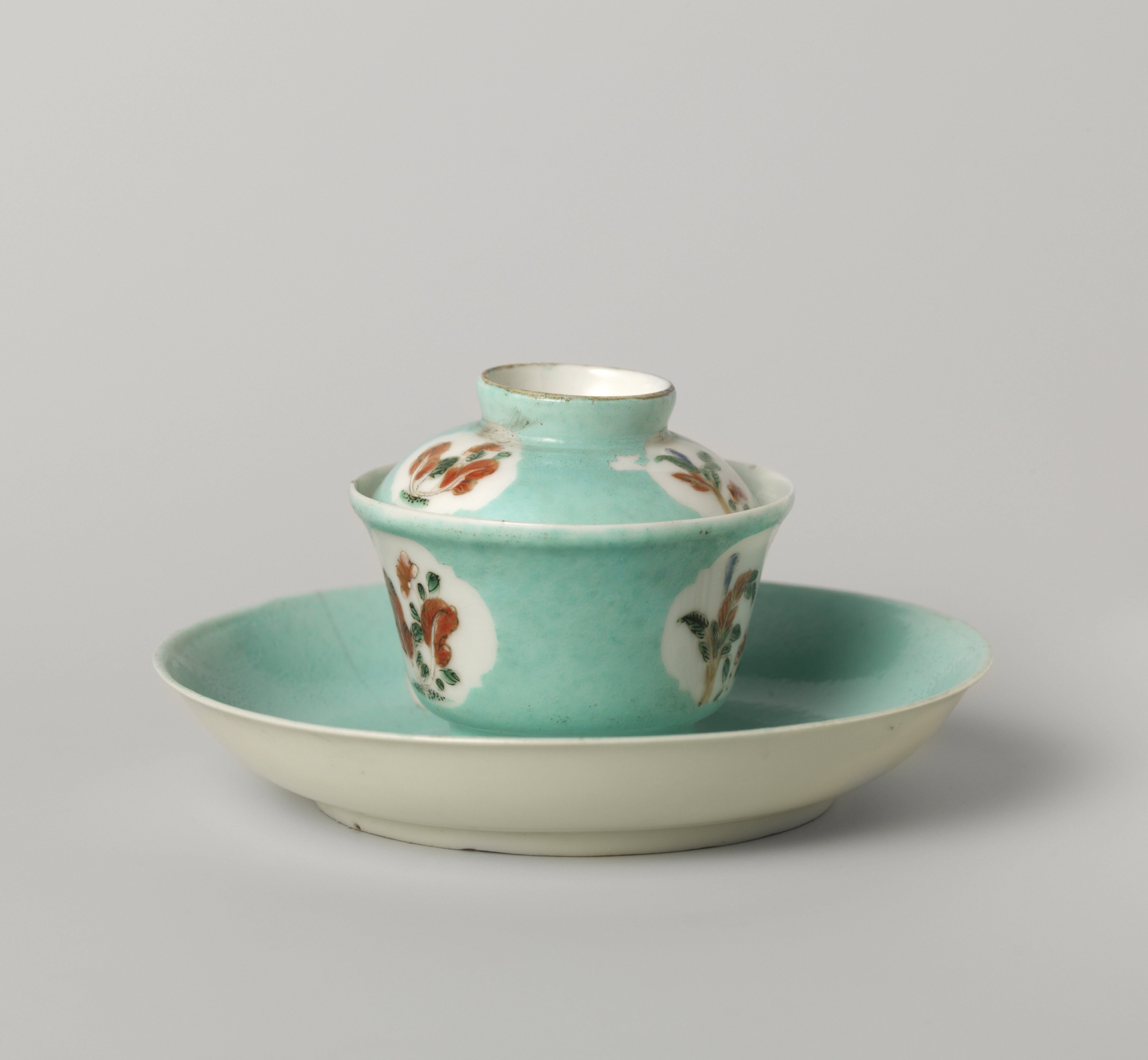 Bell-shaped covered cup and saucer with flowering plants in shaped panels