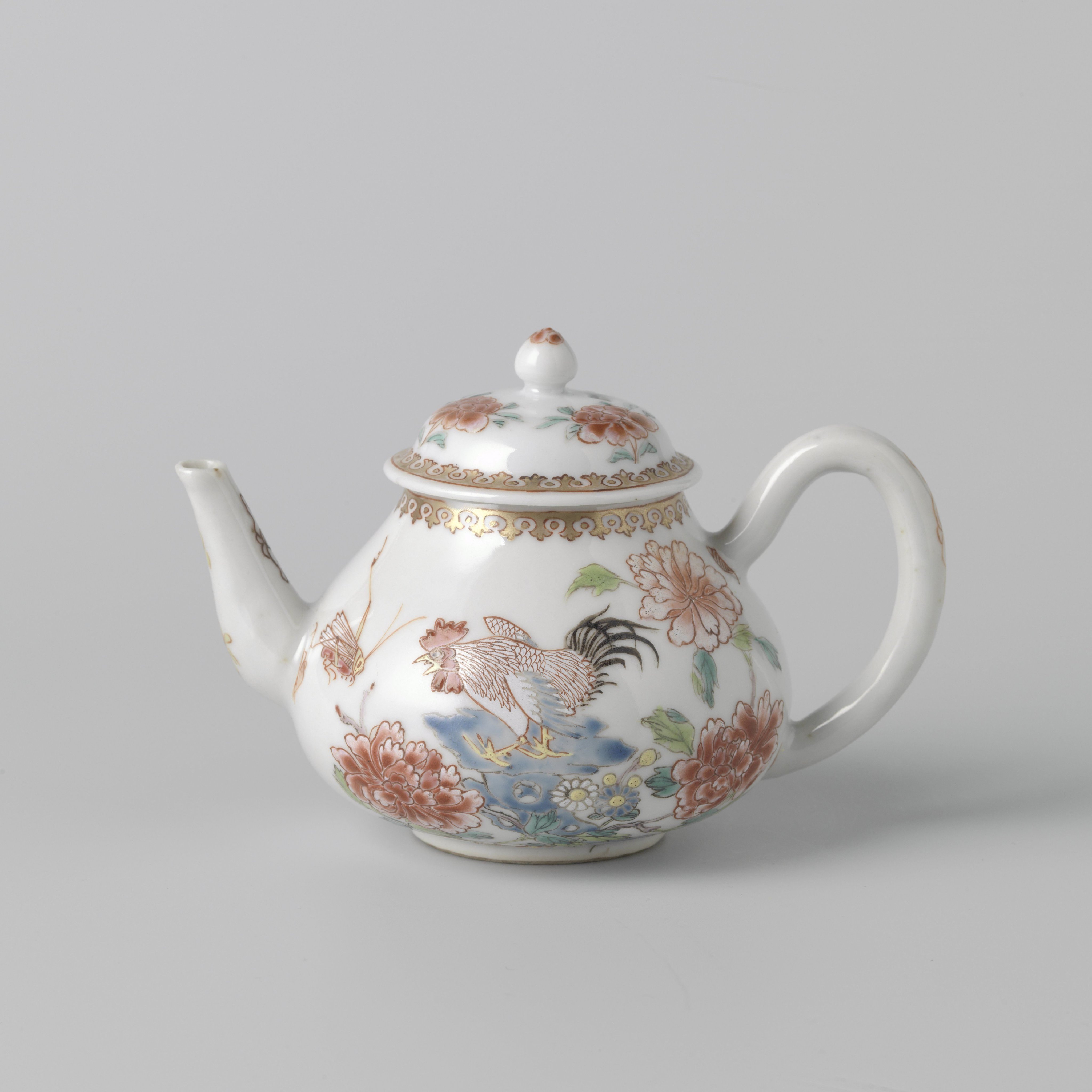Teapot with a cock on a rock near flowering plants