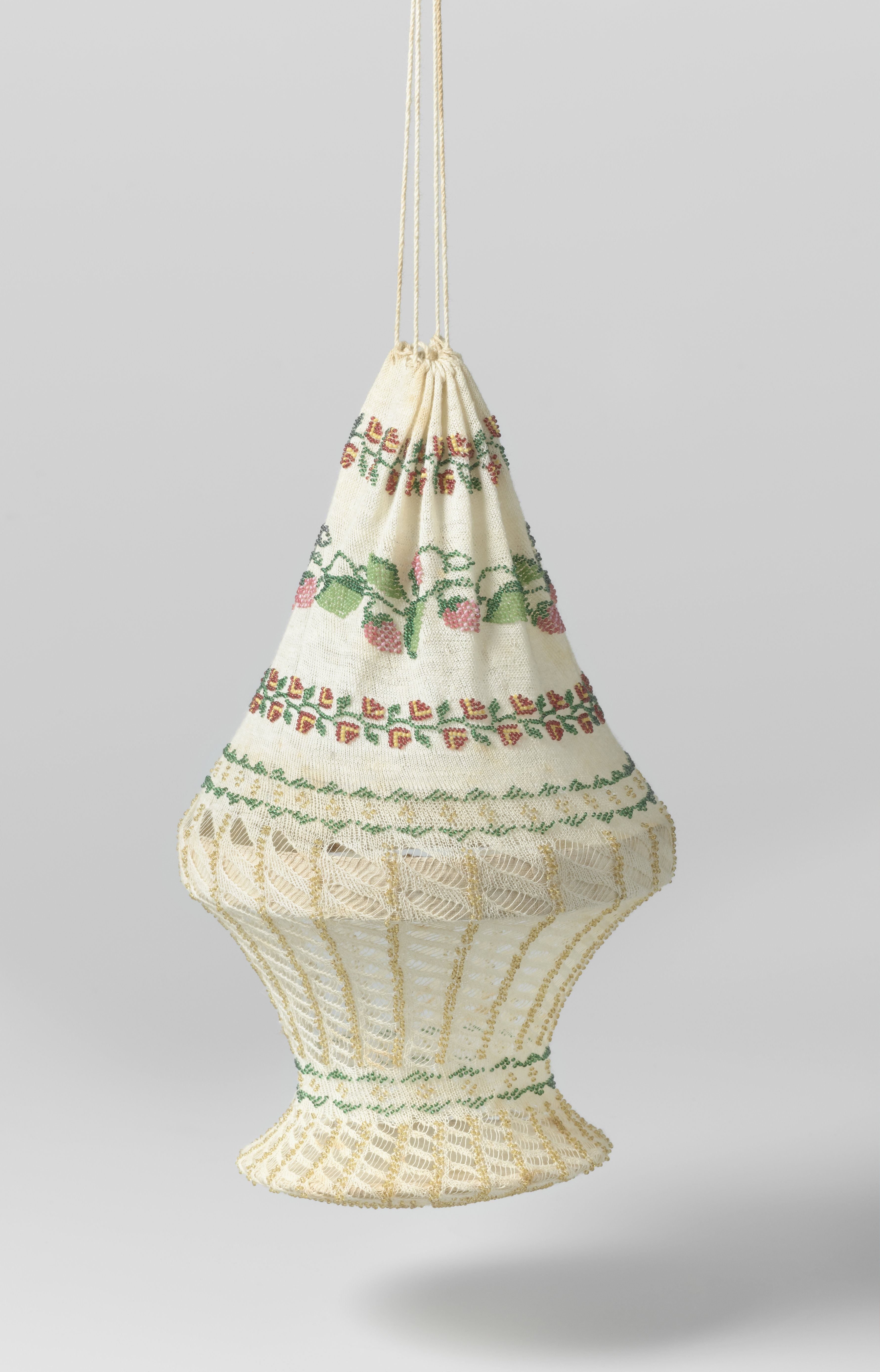 Reticule, in een ronde mandvorm, van ecrukleurig katoen met ingebreide veelkleurige kraaltjes in een patroon van bloemenranken en strepen