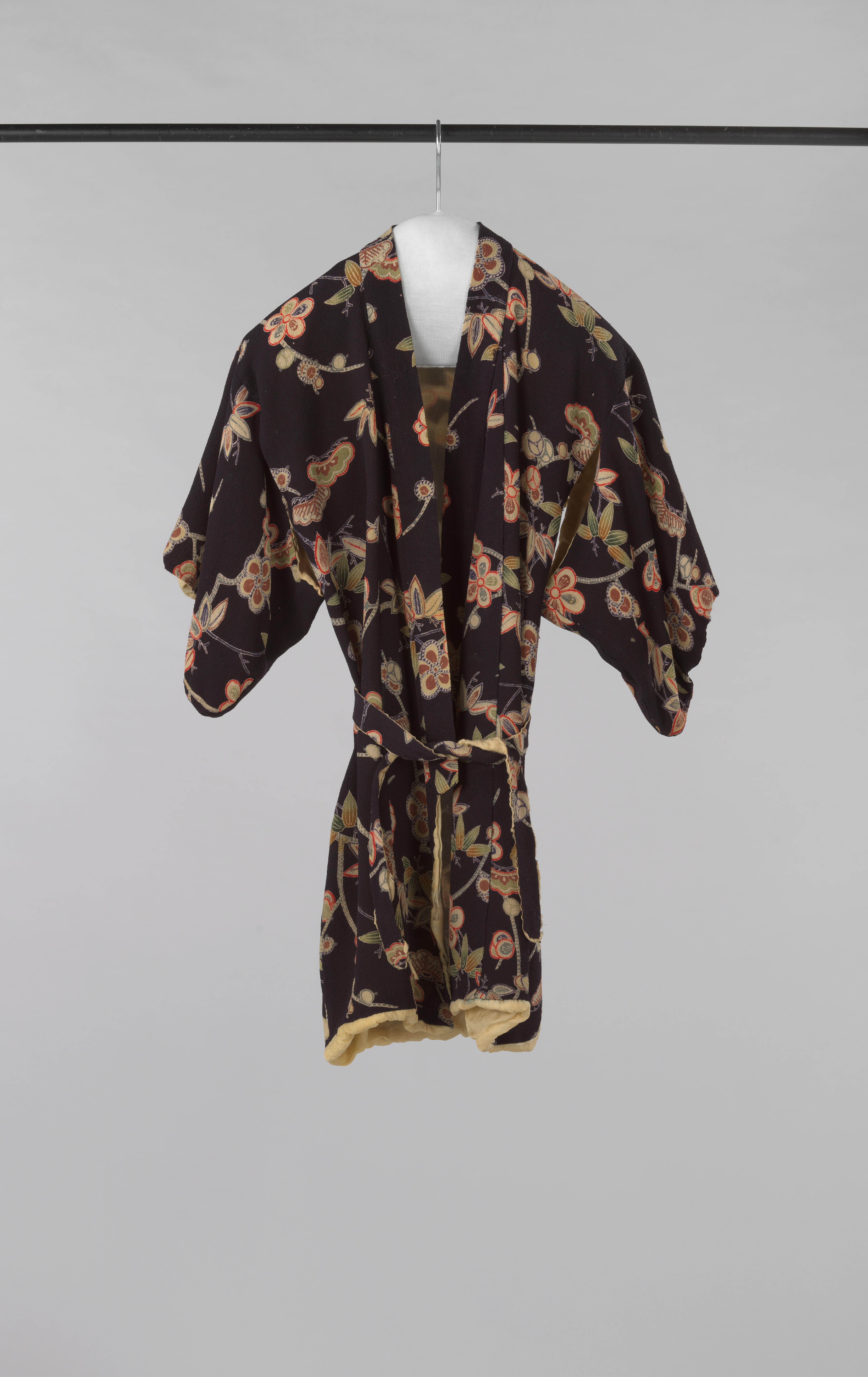 Kinderkimono met korte mouw en oksel-openingen van donkerblauwe crêpe de Chine met meerkleurige bloem- en bladmotieven; voering beige zijde