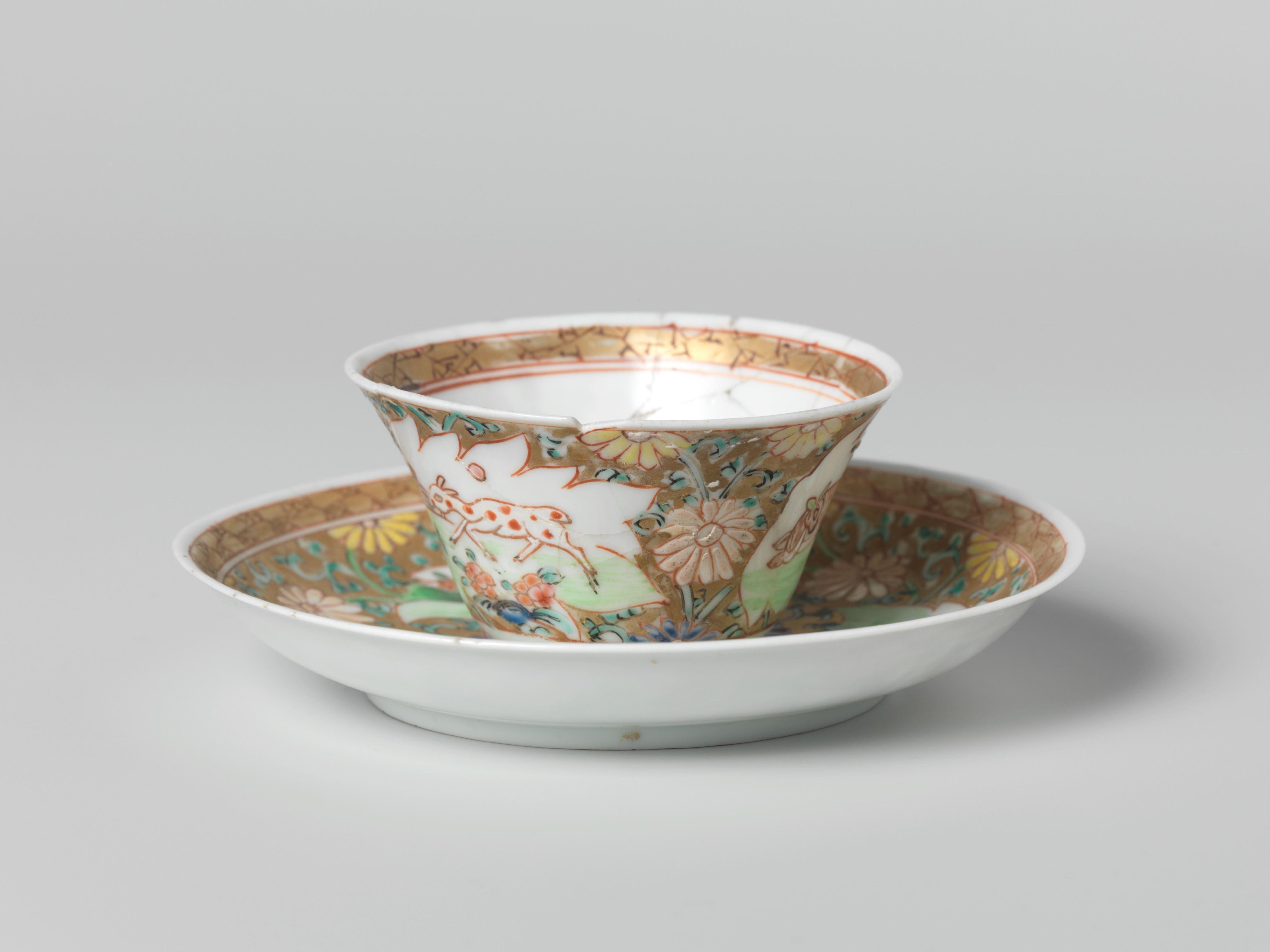 Cup and saucer with a cock and three deer in panels on a gold ground with floral scrolls