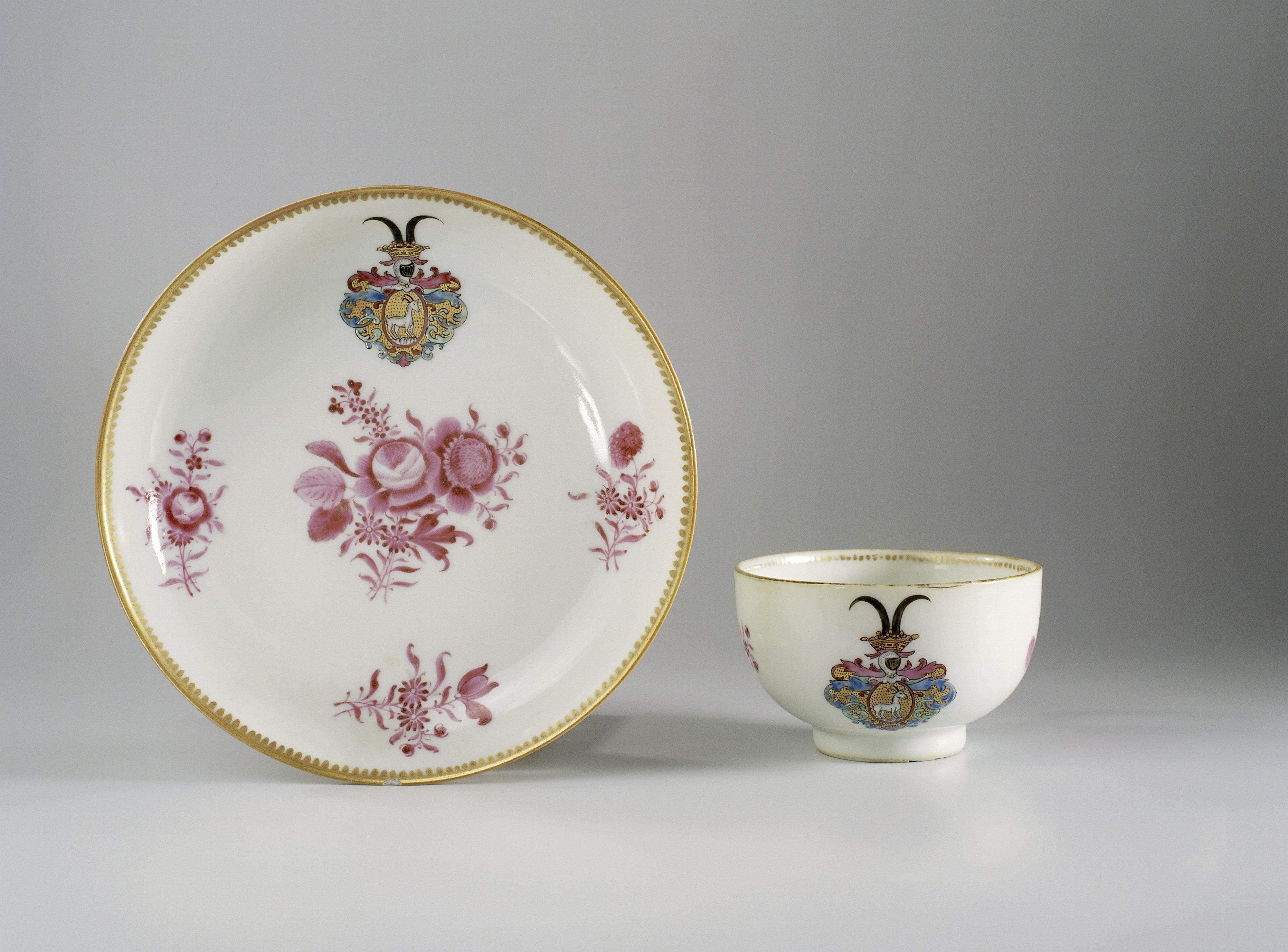 Cup with handle and saucer with flower bouquets and a coat of arms