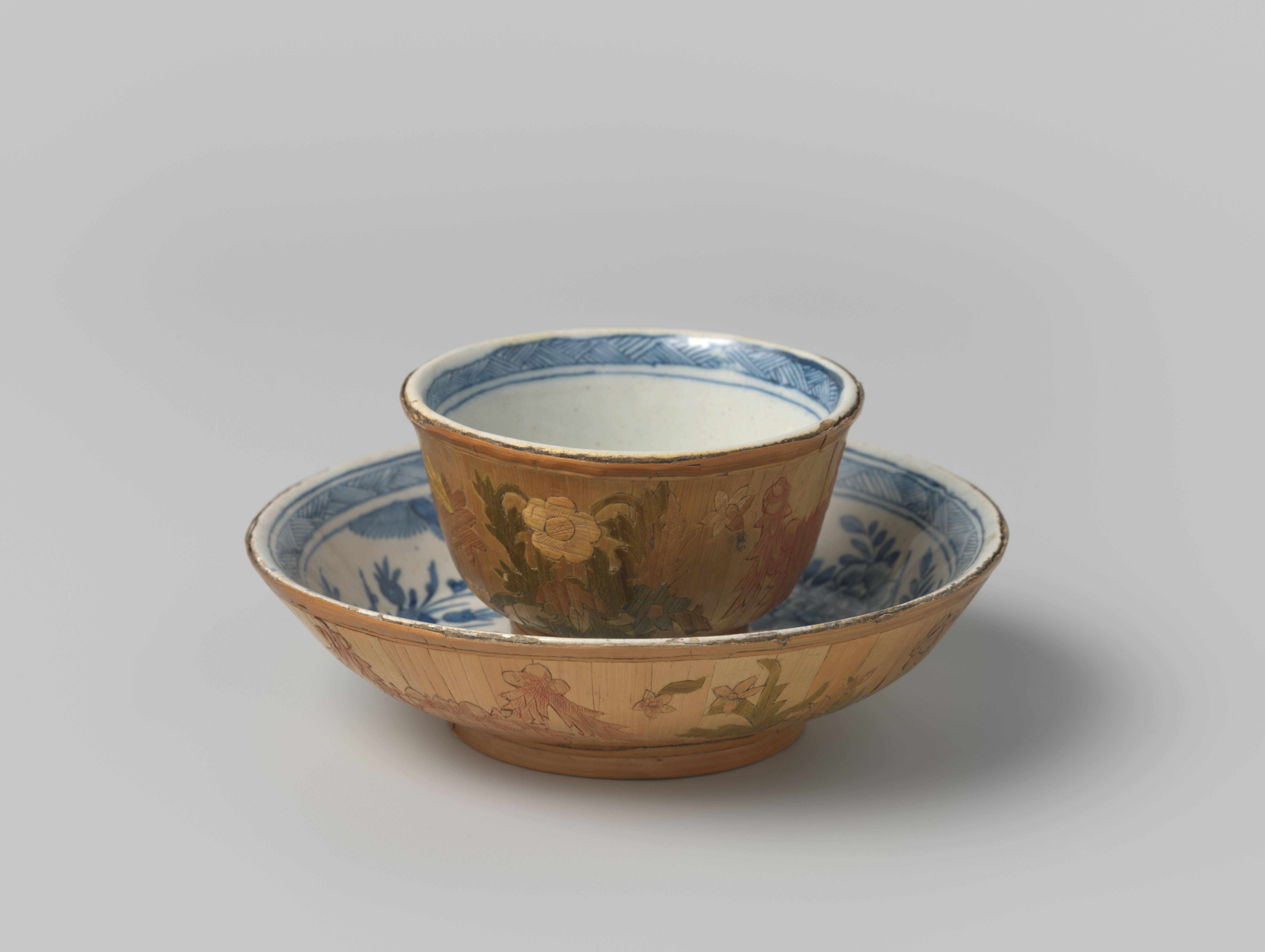 Kop en schotel van faience en stro met bloemdecoratie