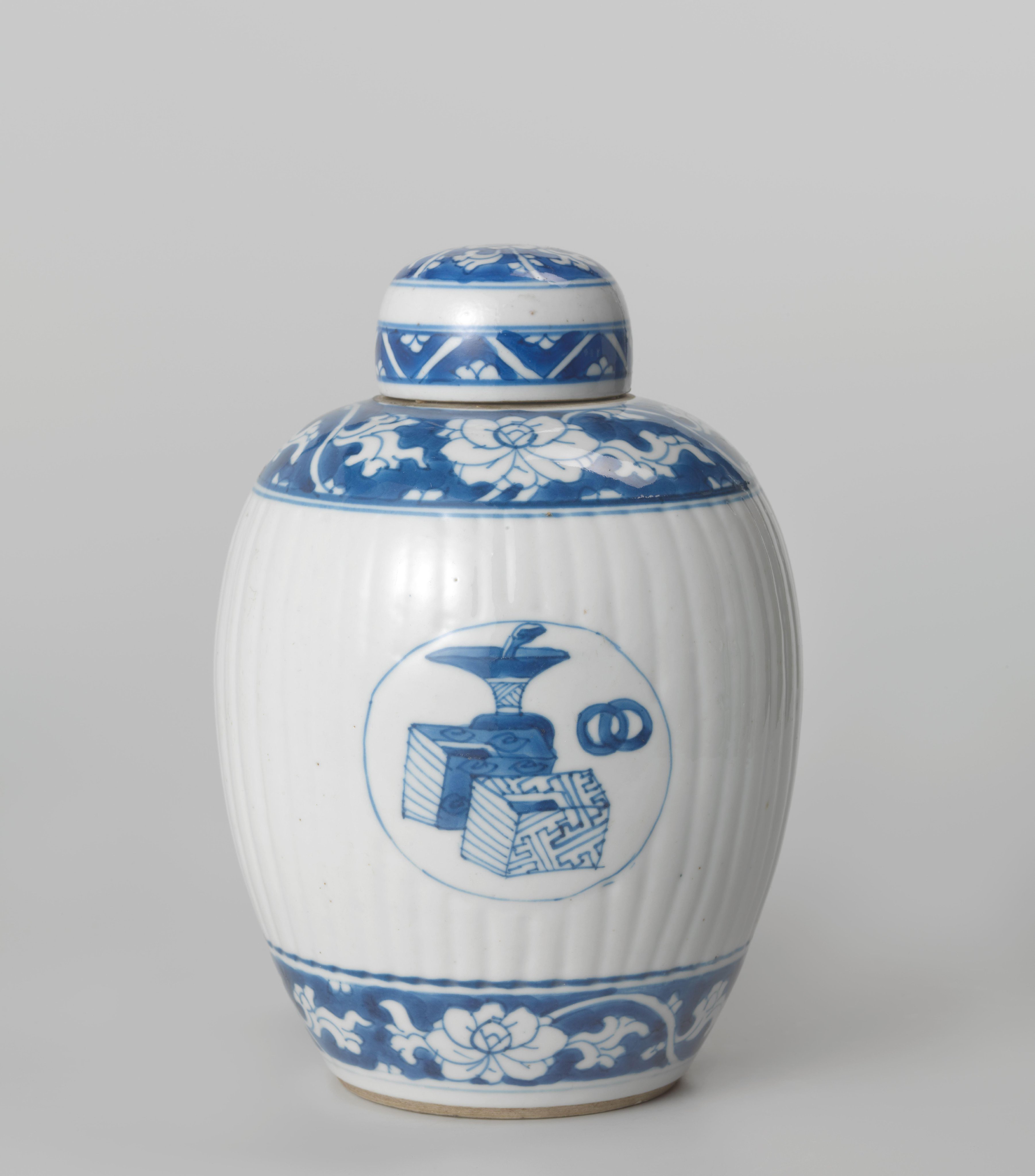Ovoid fluted covered jar with precious objects in medallions and floral scrolls