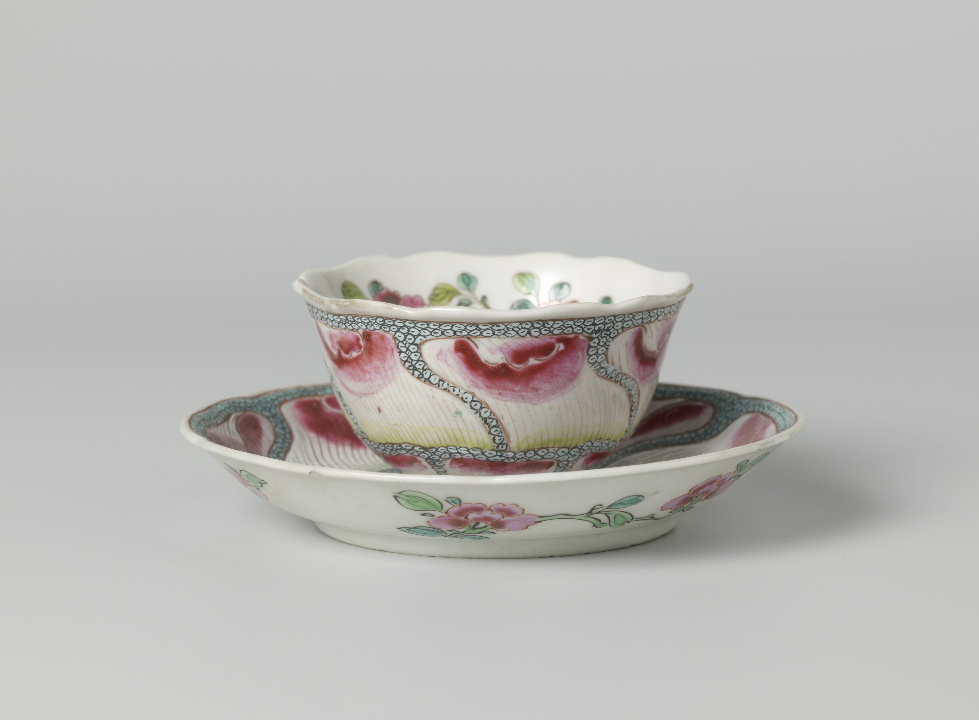 Bell-shaped cup and saucer with undulating flower petals on diaper pattern and flower sprays