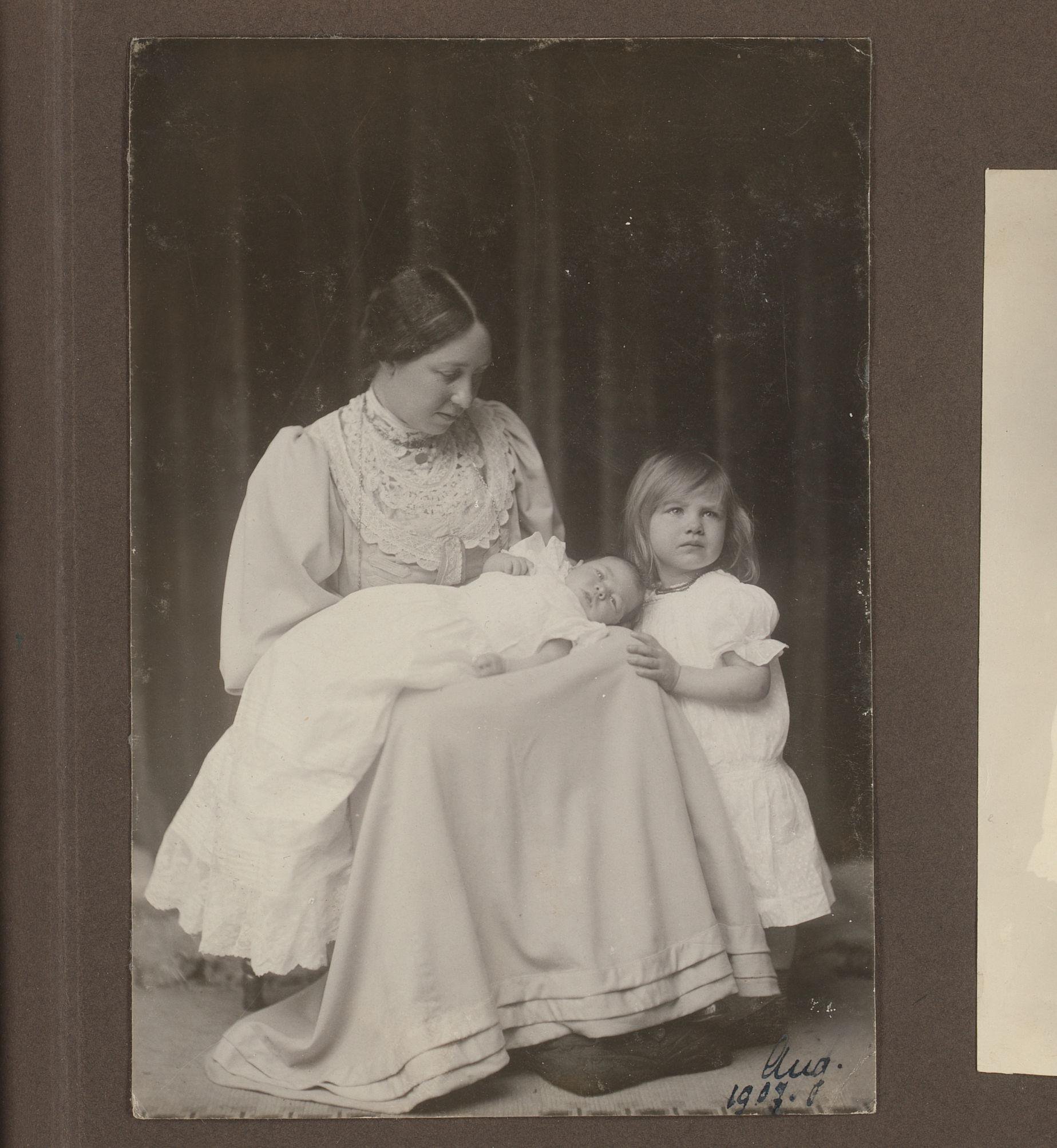 Portret van Elsa Diepenbrock met Thea op schoot in een doopjurk en Joanna staand ernaast