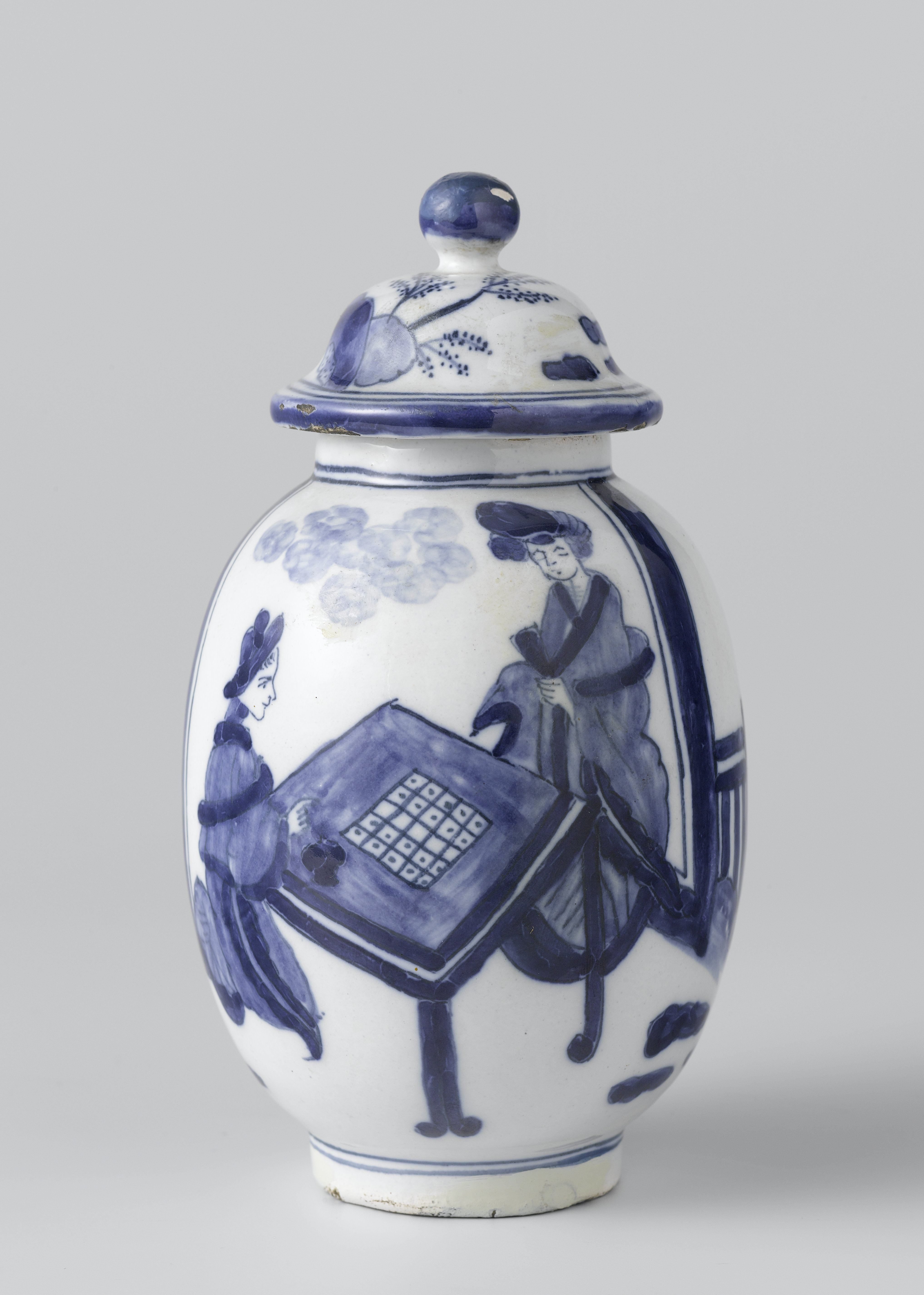 Dekselpot van blauw beschilderde faience met voorstelling van twee bordspelers en rotsen
