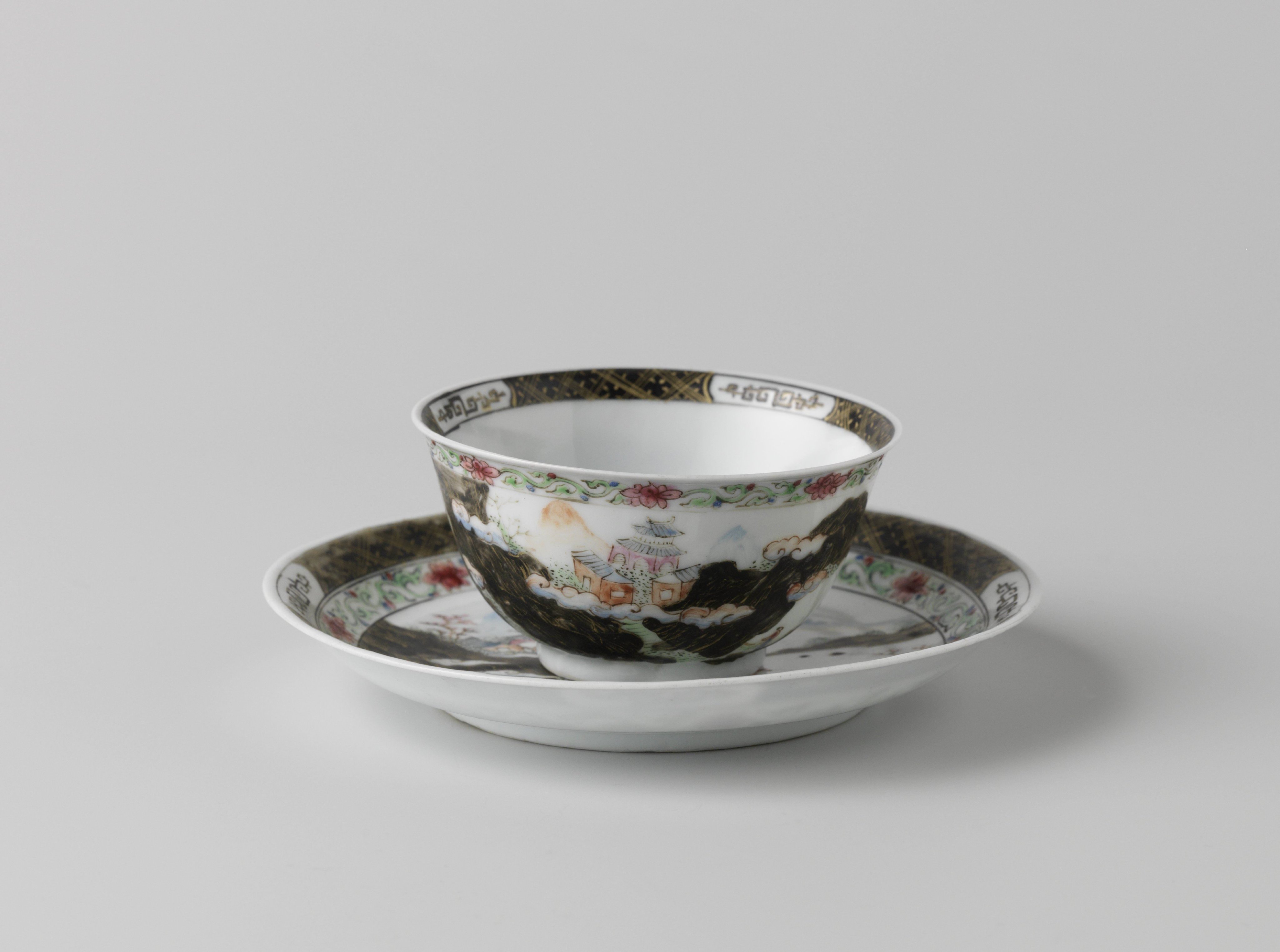 Bell-shaped cup and saucer with a mountainous landscape with pavilion, river and trees