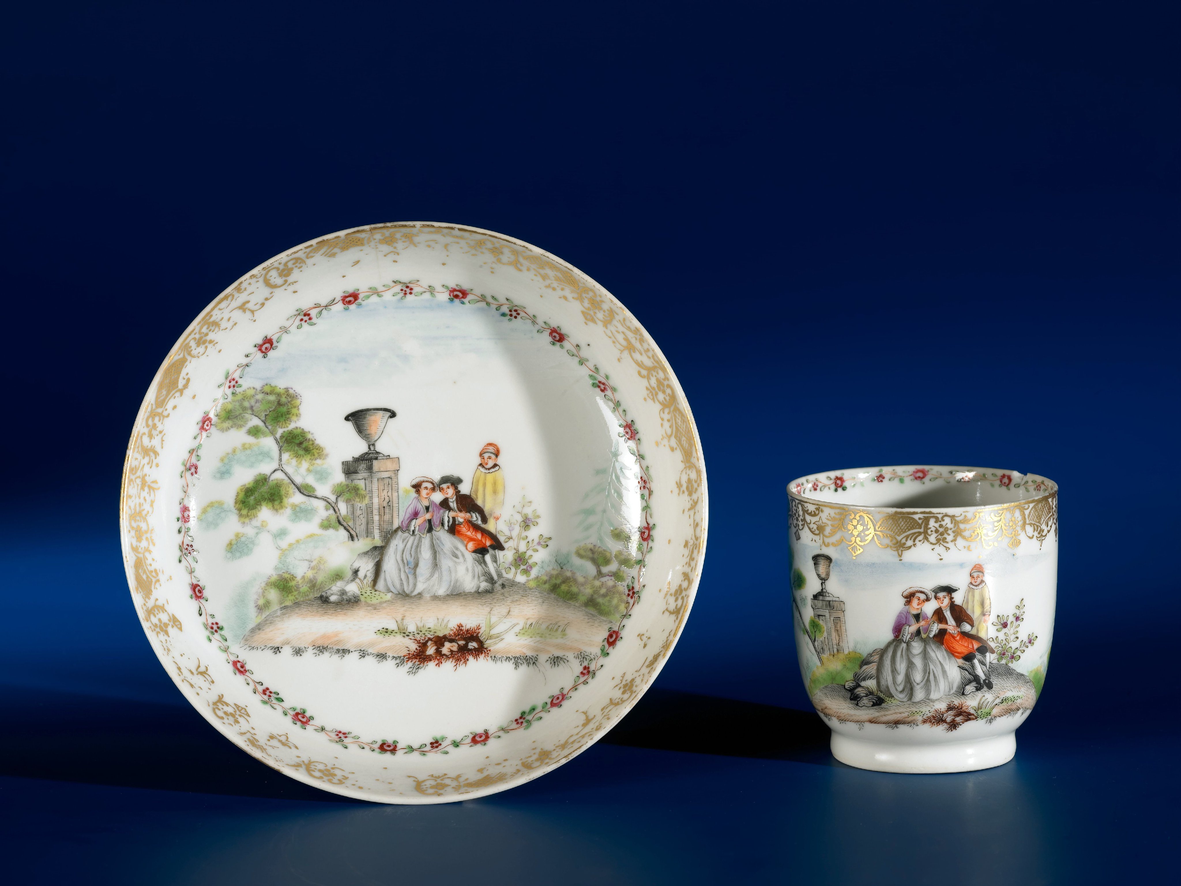 Cup with handle and saucer with an European couple sitting in a landscape