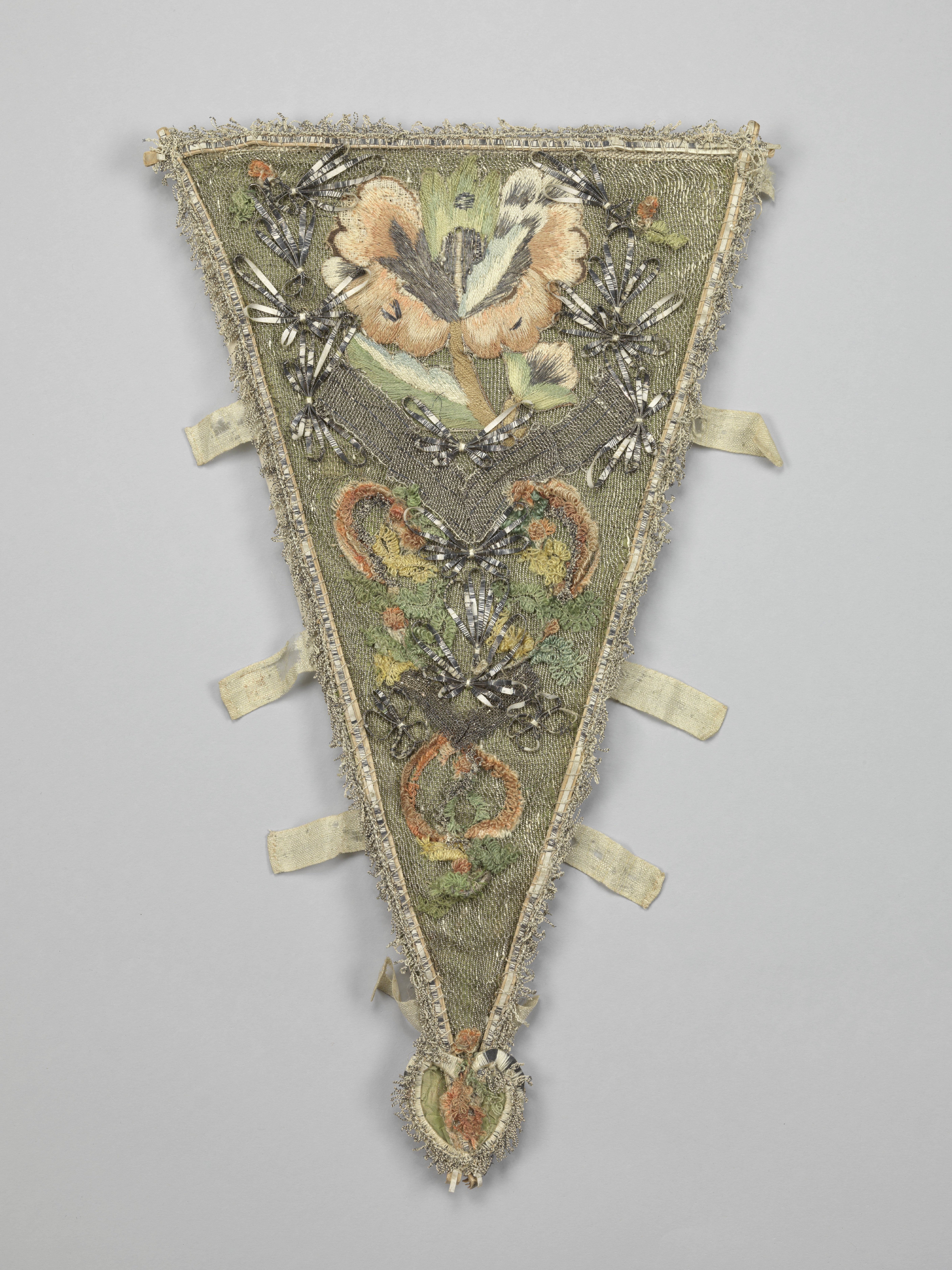 Driehoekig borststuk van lichtgroene zijde, versierd met zilvergaas waarop bloemenappliques van veelkleurige chenille