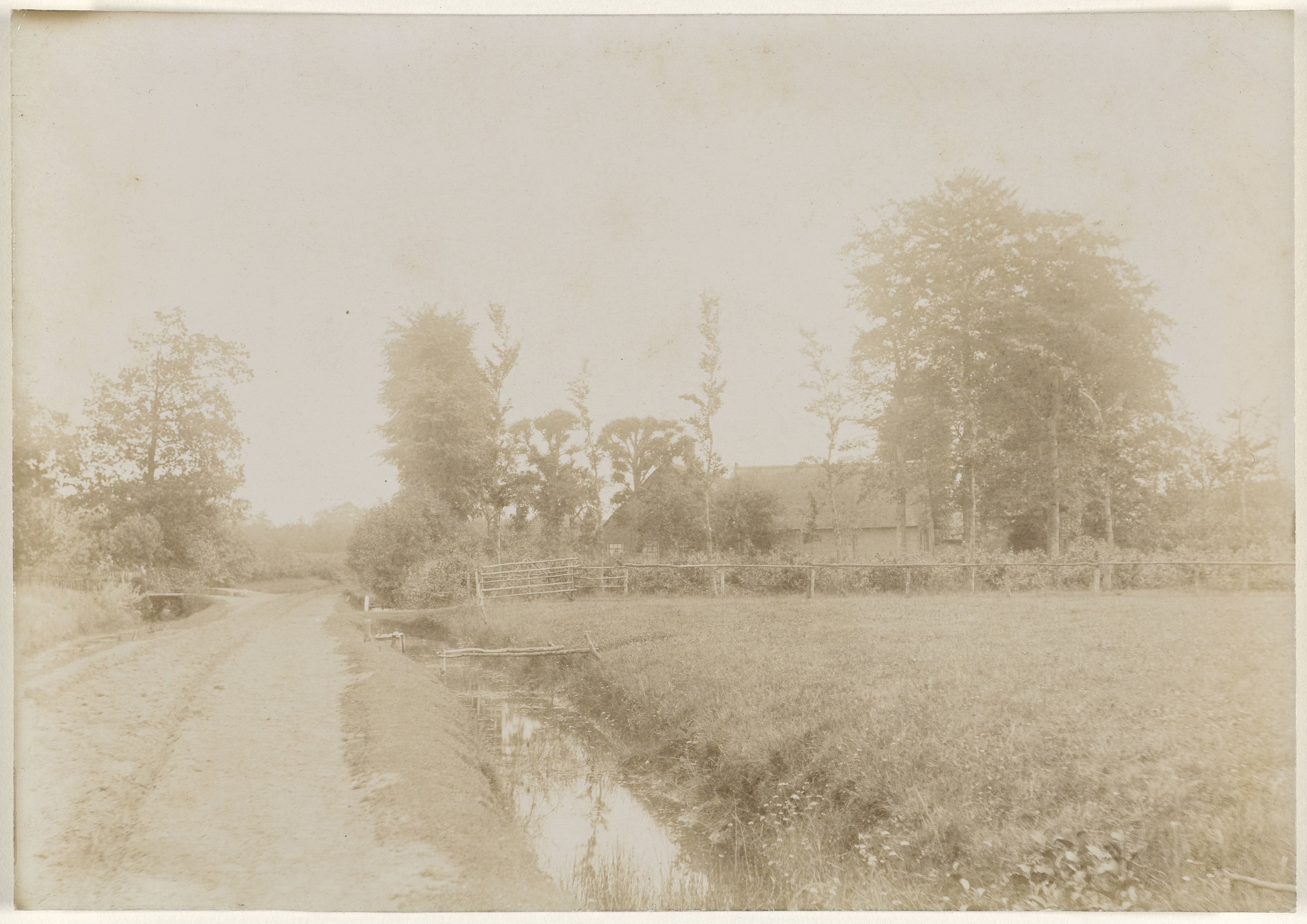Landschap met bomen, een sloot, een boerderij en een landweg