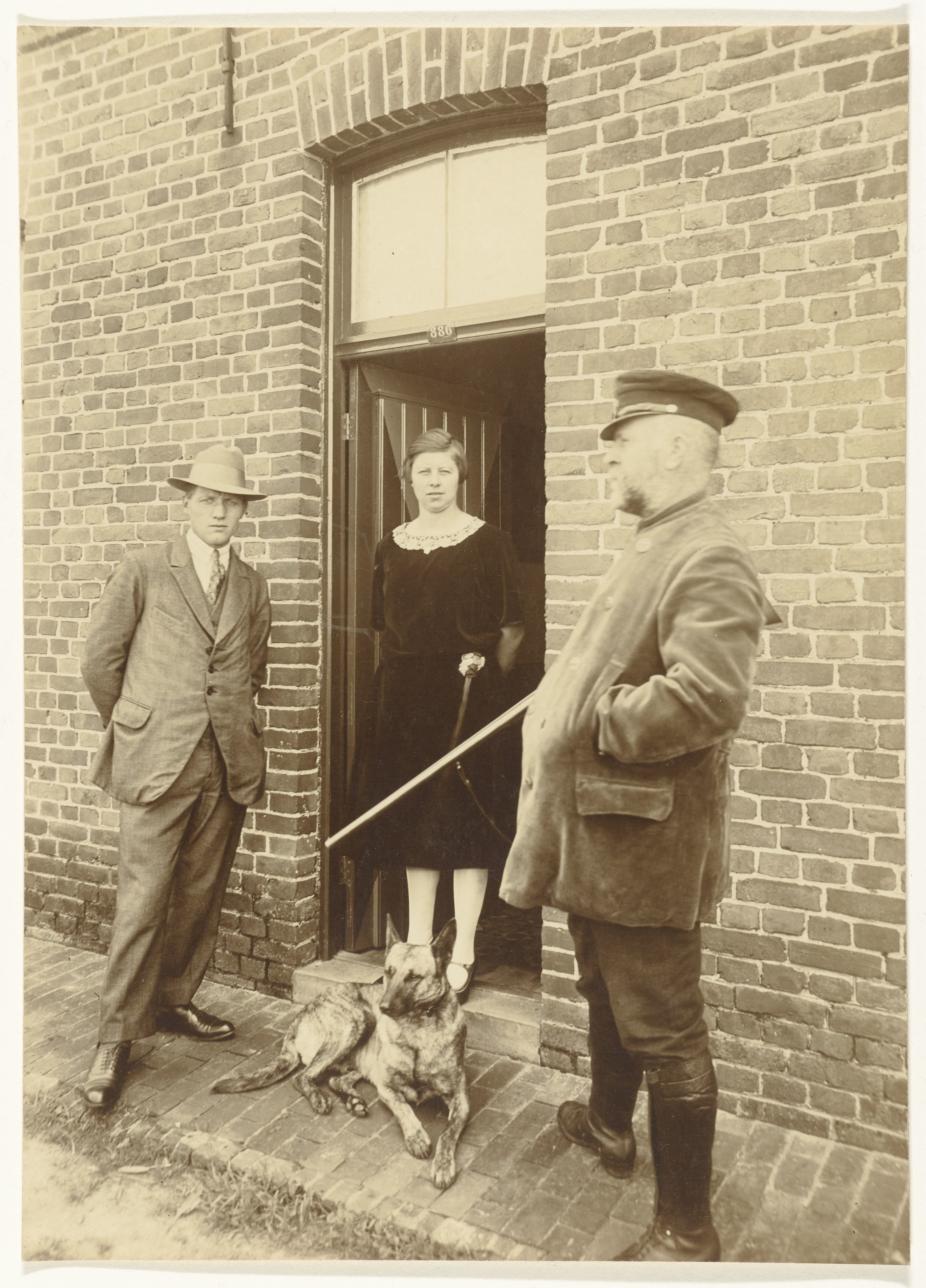 Portret van een drietal in een deuropening met een hond
