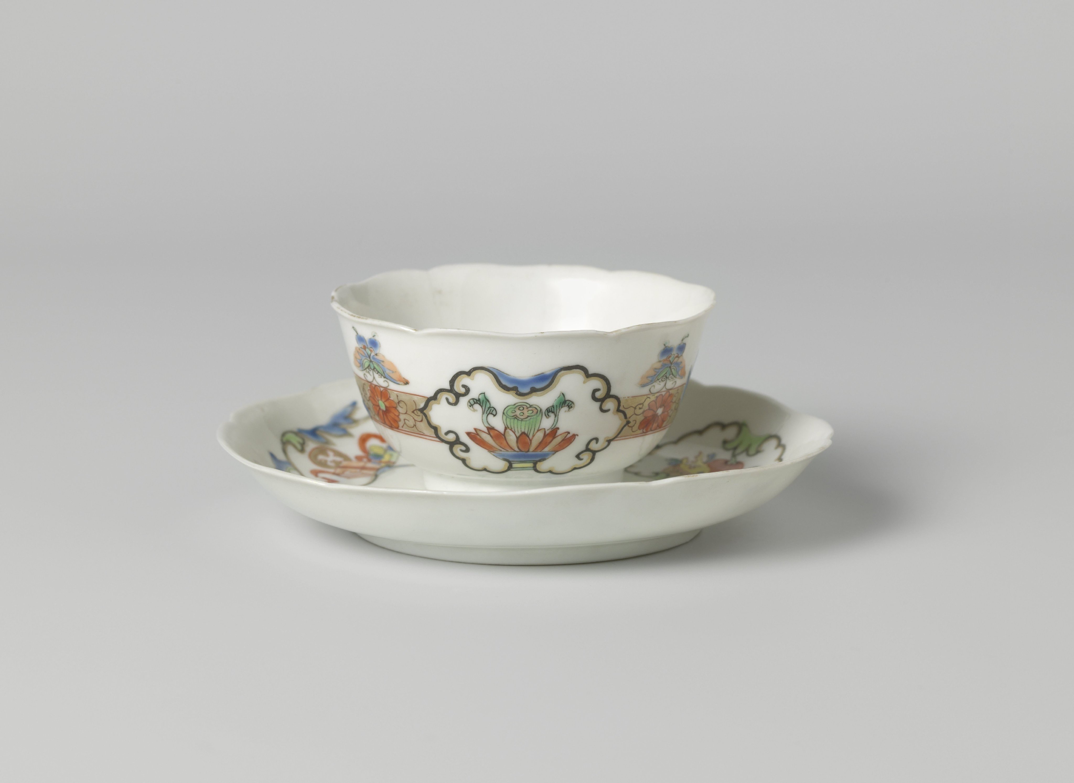 Bell-shaped cup and saucer with butterflies, floral scrolls and auspicious objects in panels