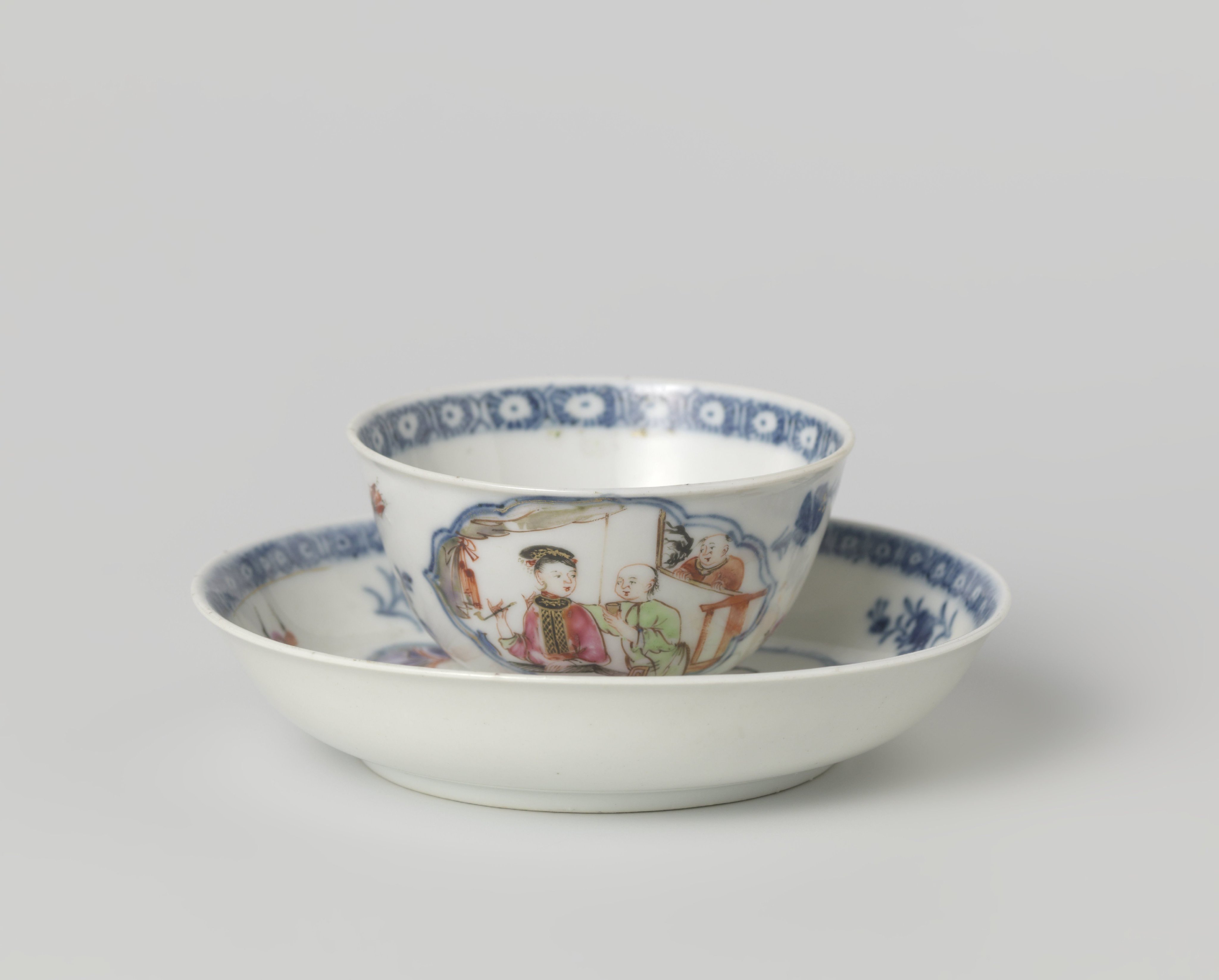 Bell-shaped cup and saucer with a man and woman in an interior in a scalloped panel