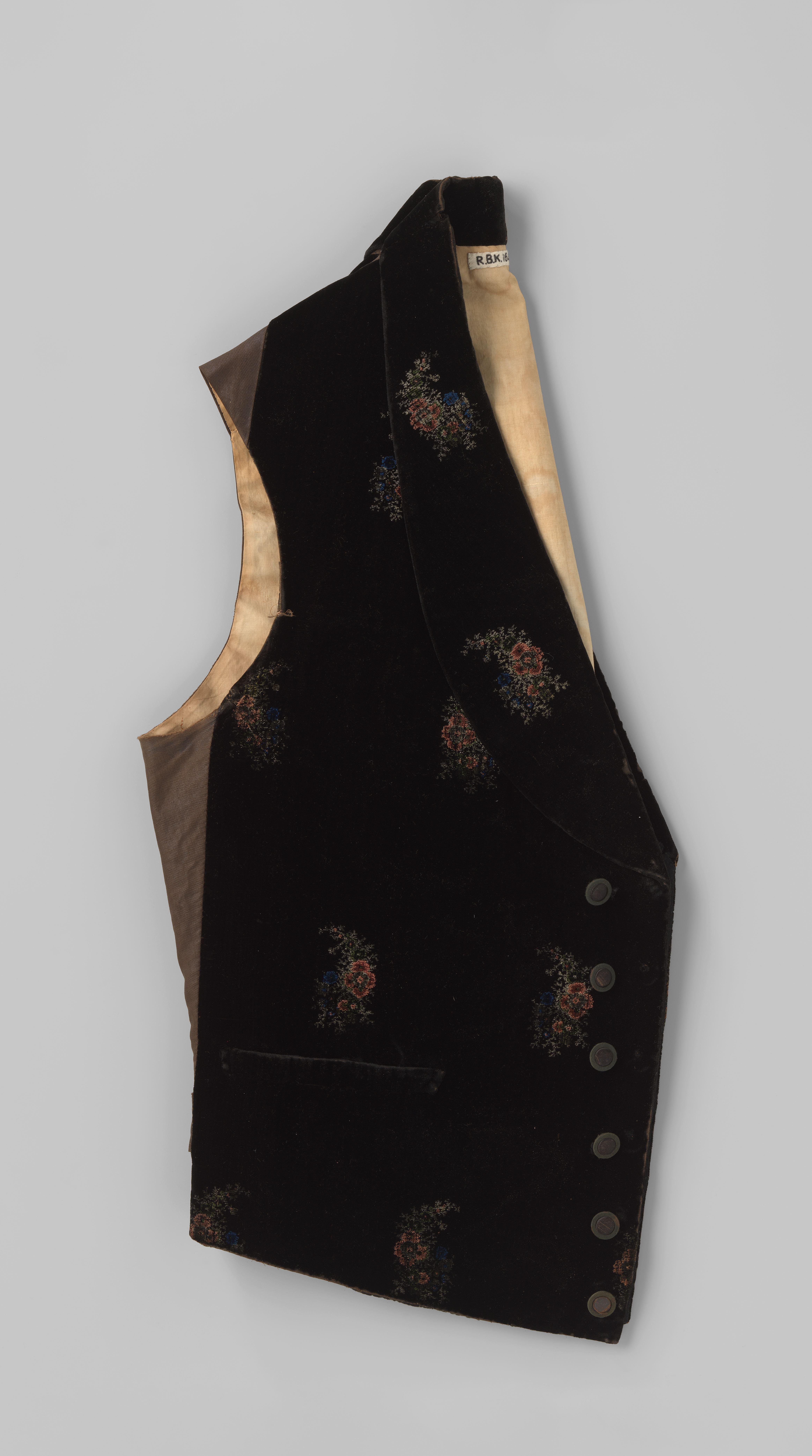 Vest van zwart fluweel met ingeweven bloemmotieven in verschillende tinten bruin, groen, wit en blauw