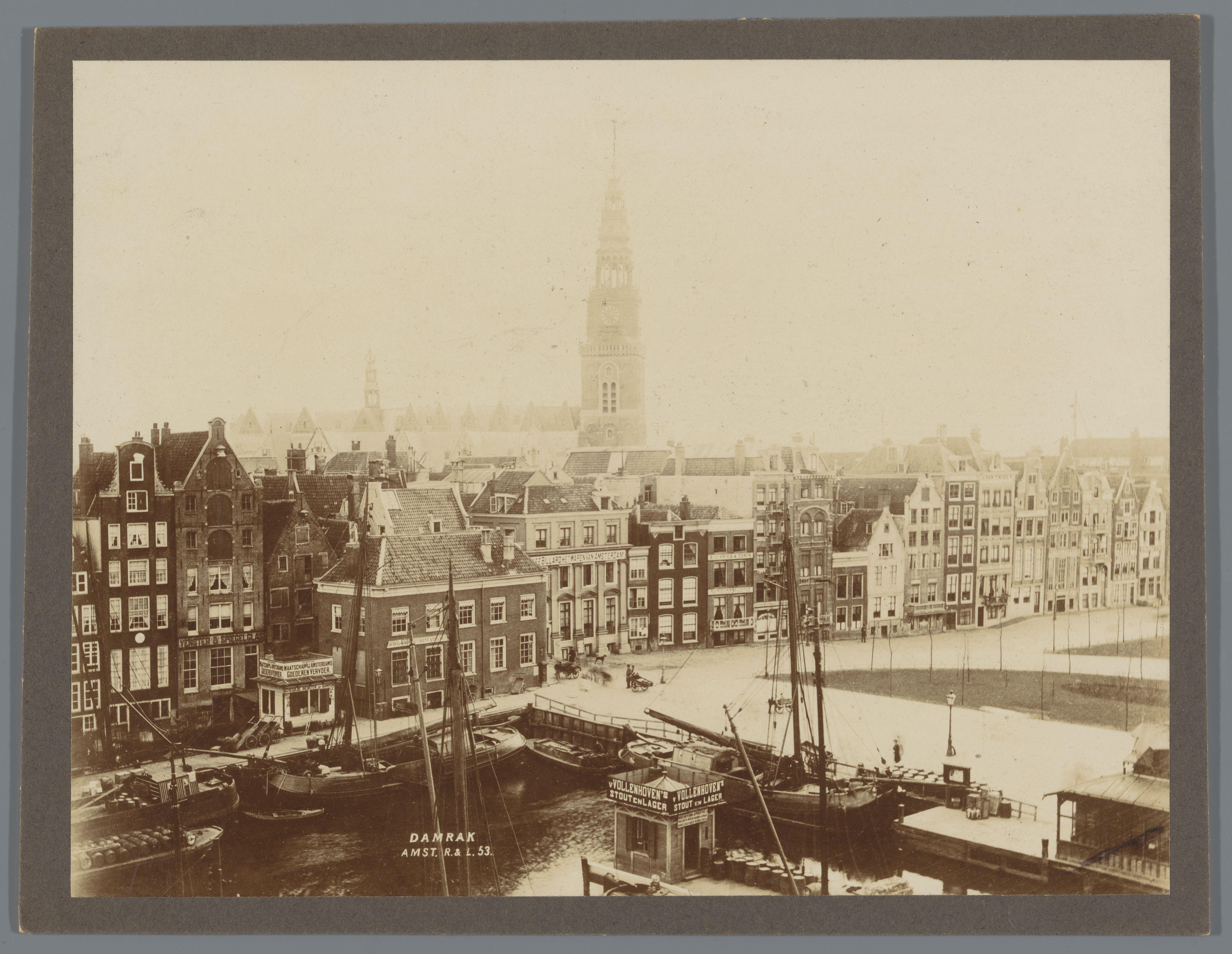 Gezicht op het Damrak met op de achtergrond de torens van de Oude Kerk en de Zuiderkerk te Amsterdam