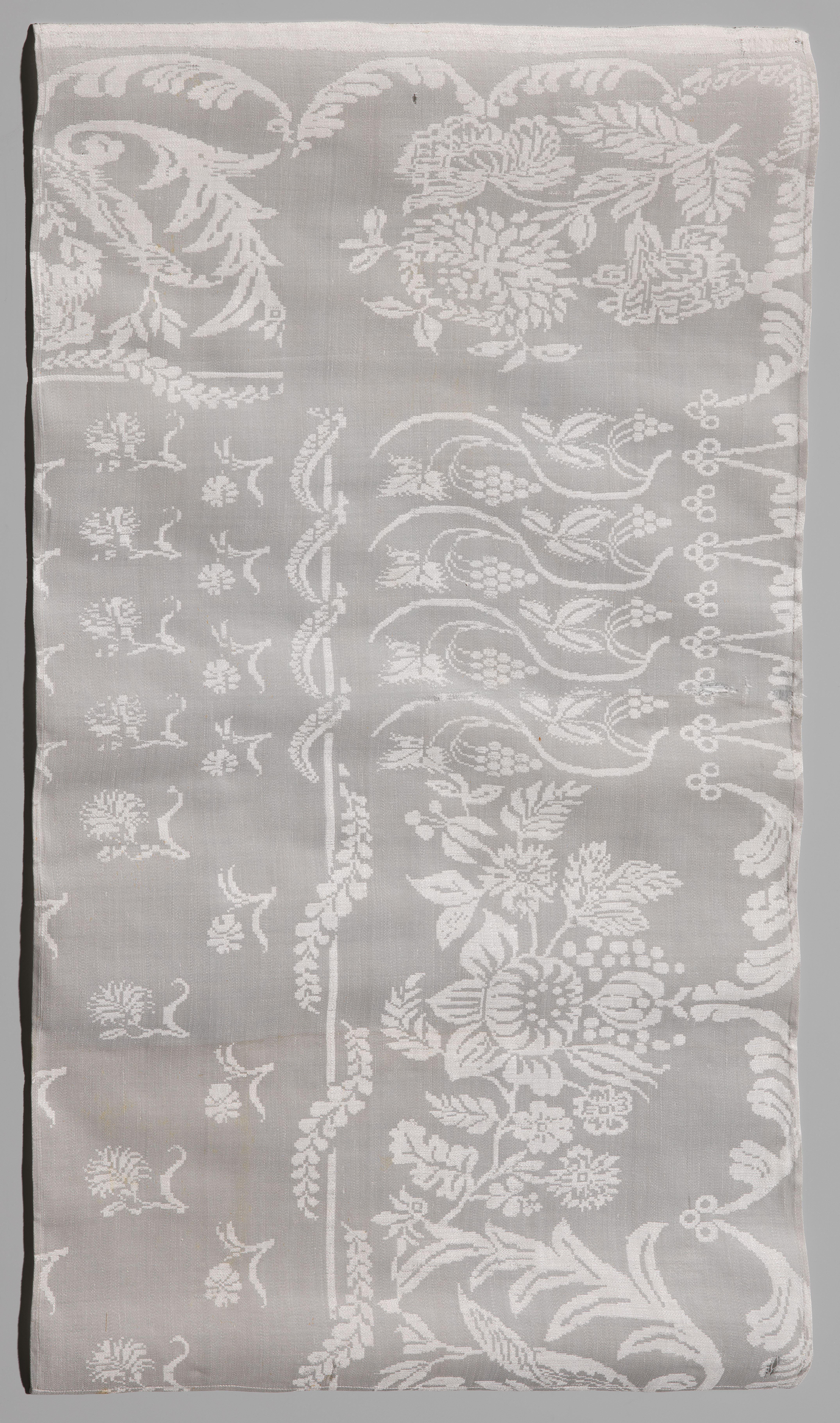 Tafellaken, fragment, met patroon van druiven- en bloemtakken en gestrooide bloemen
