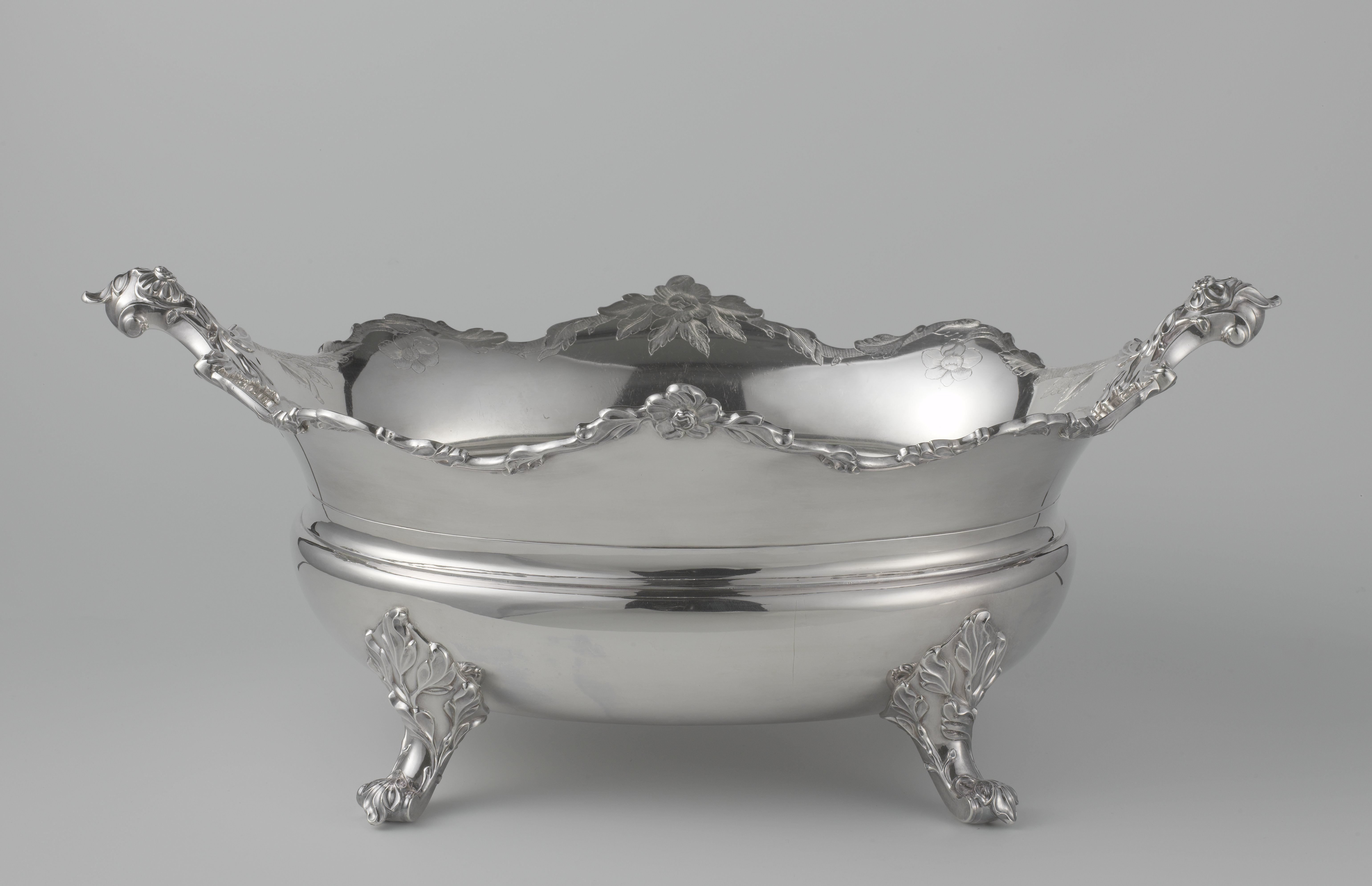 Koelvat van zilver, ovaal, op vier poten. Gladde gewelfde wand met bolle buik. Twee schuin opstaande oren.