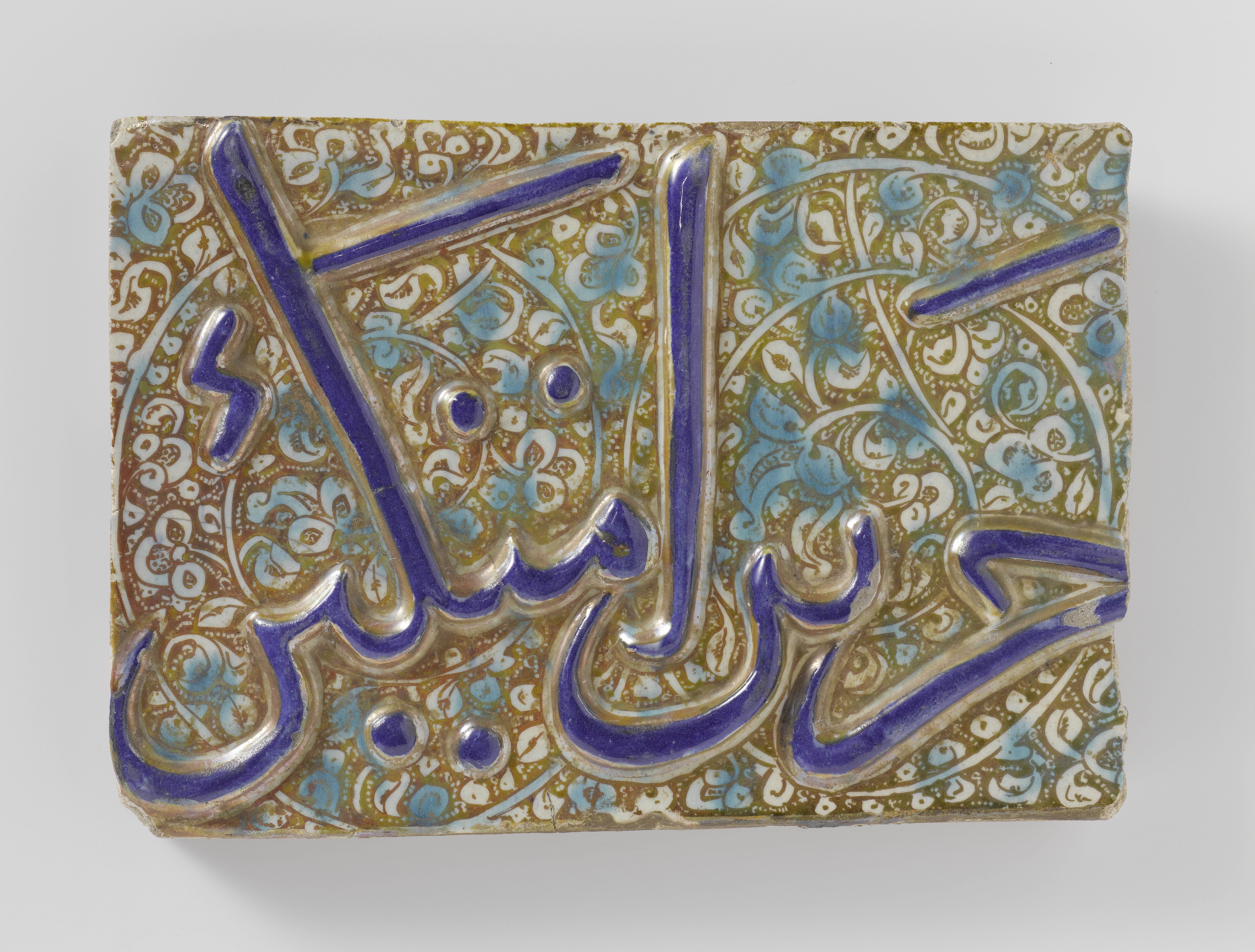 Rectangular tile with an inscription and foliate scrolls