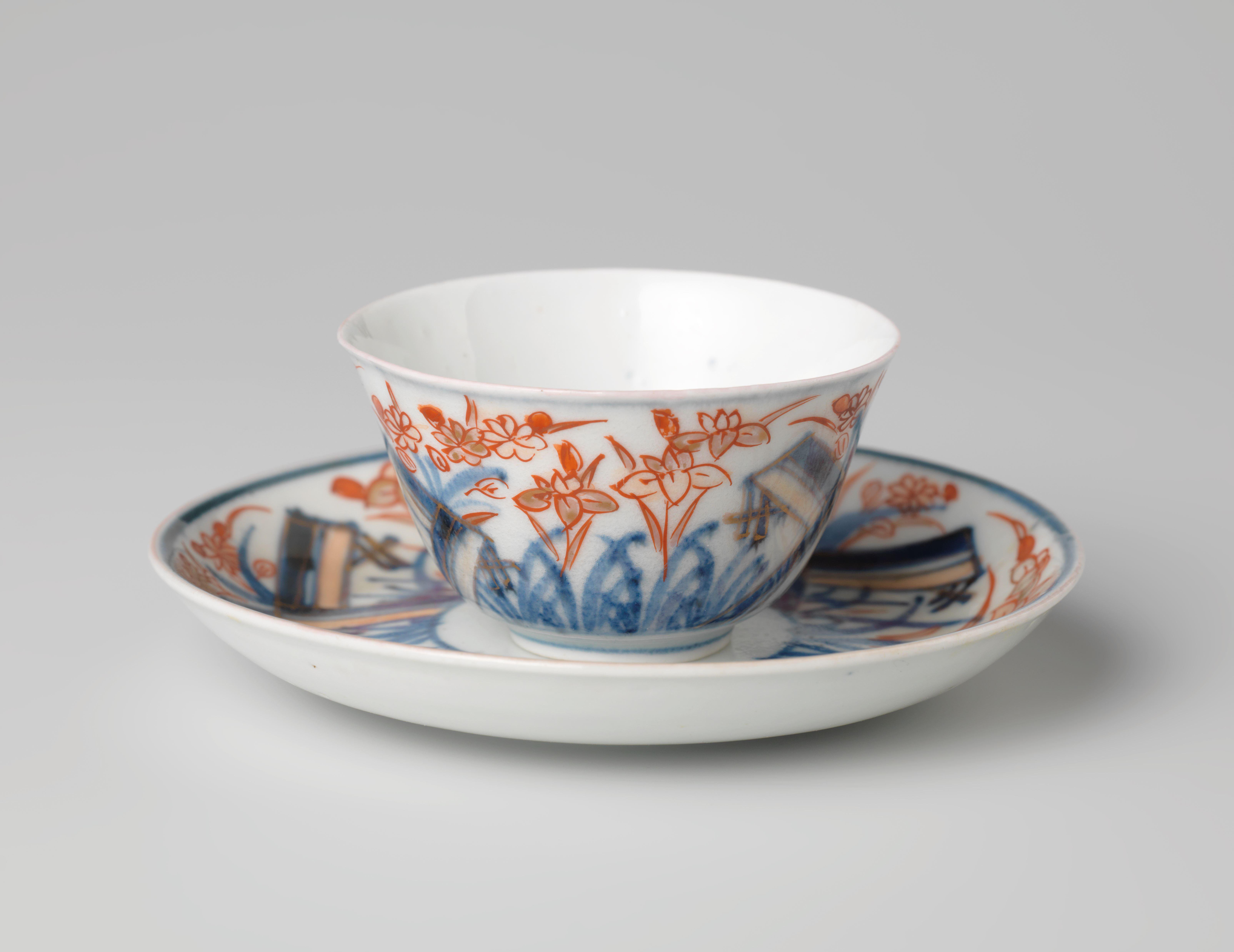 Bell-shaped cup and saucer with a flower spray and flowering plants