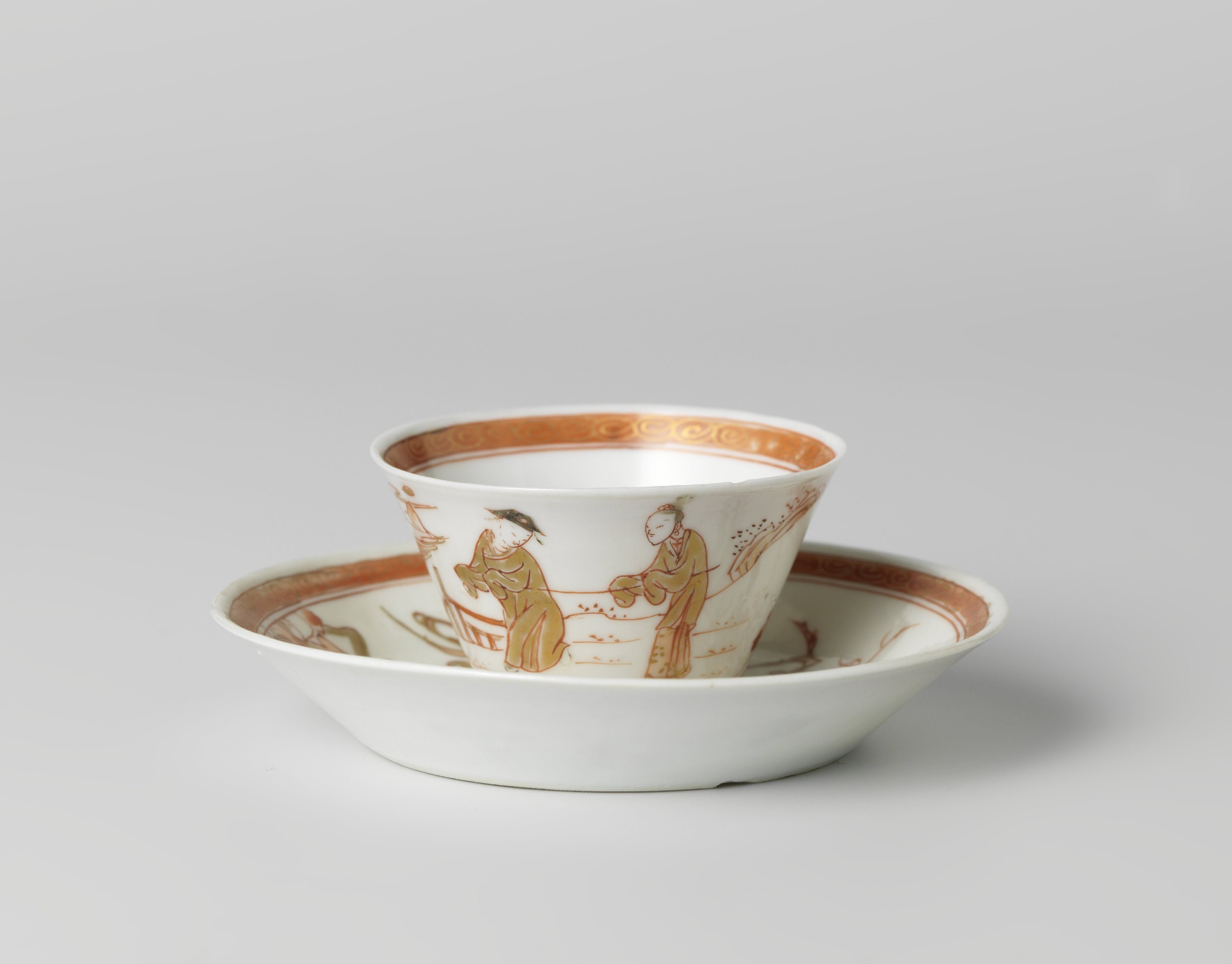 Cup and saucer with two figures in a water landscape and a flowering tree