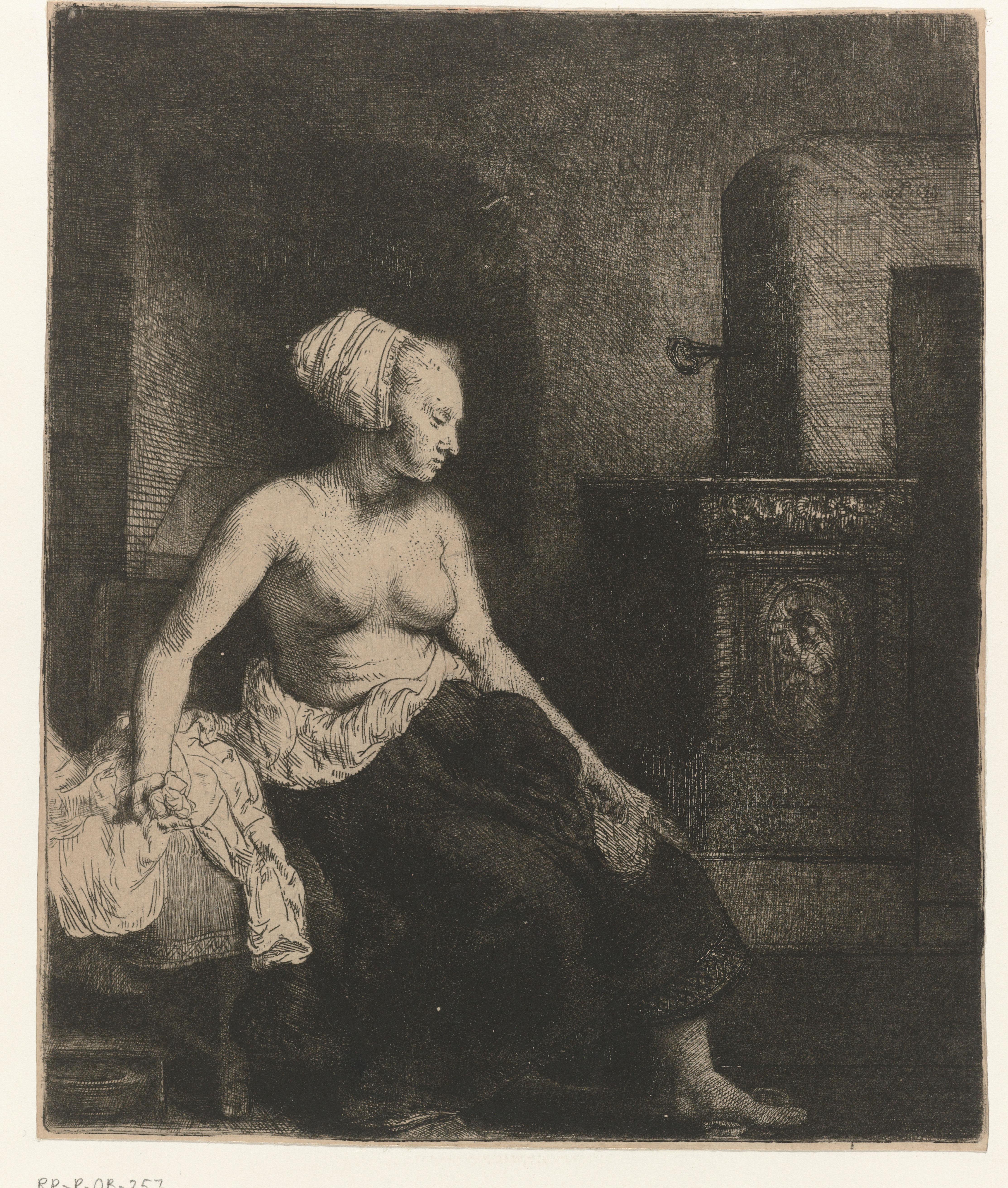 Woman sitting half dressed beside a stove