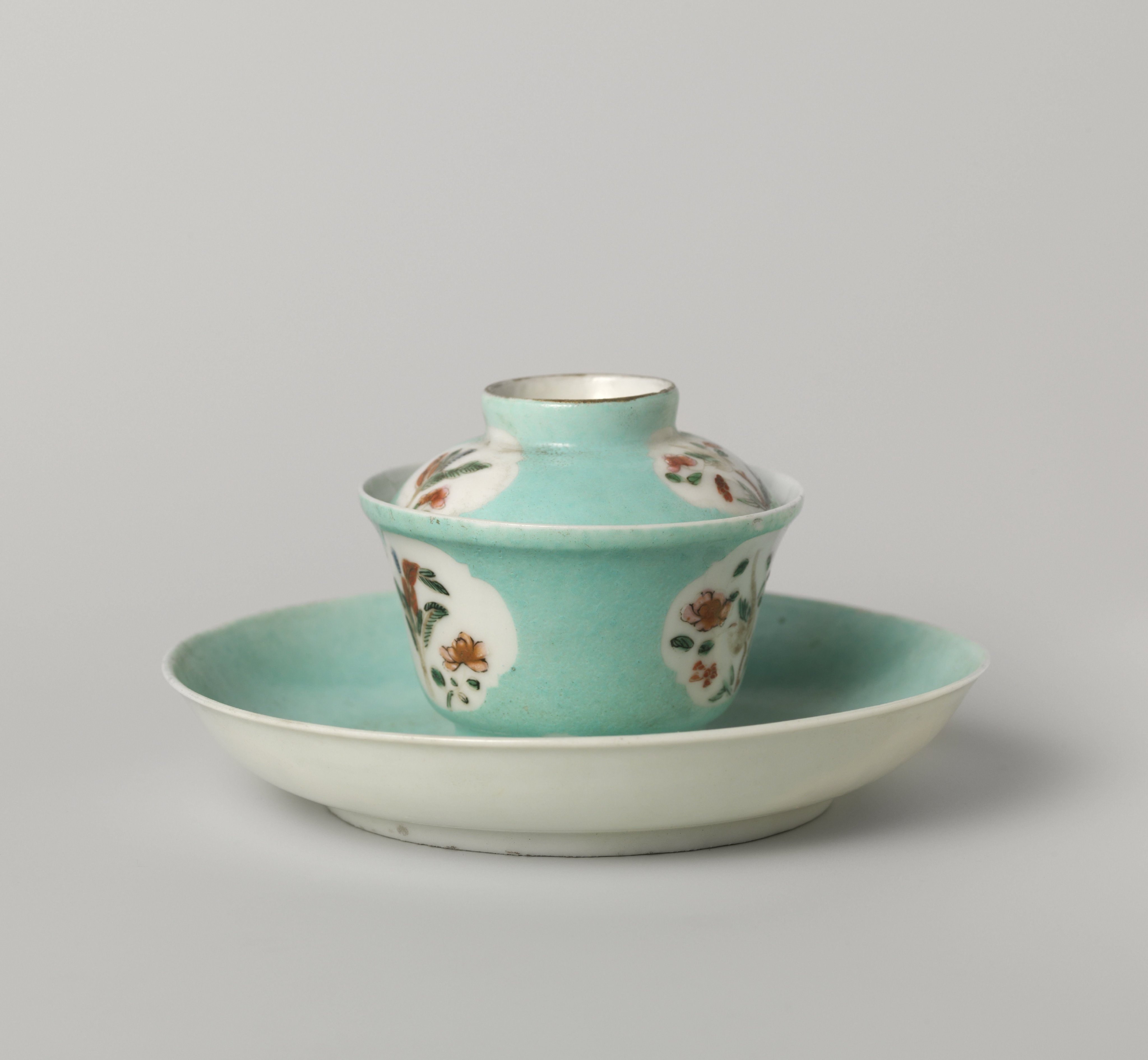 Bell-shaped covered cup and saucer with flowering plants in shaped panels