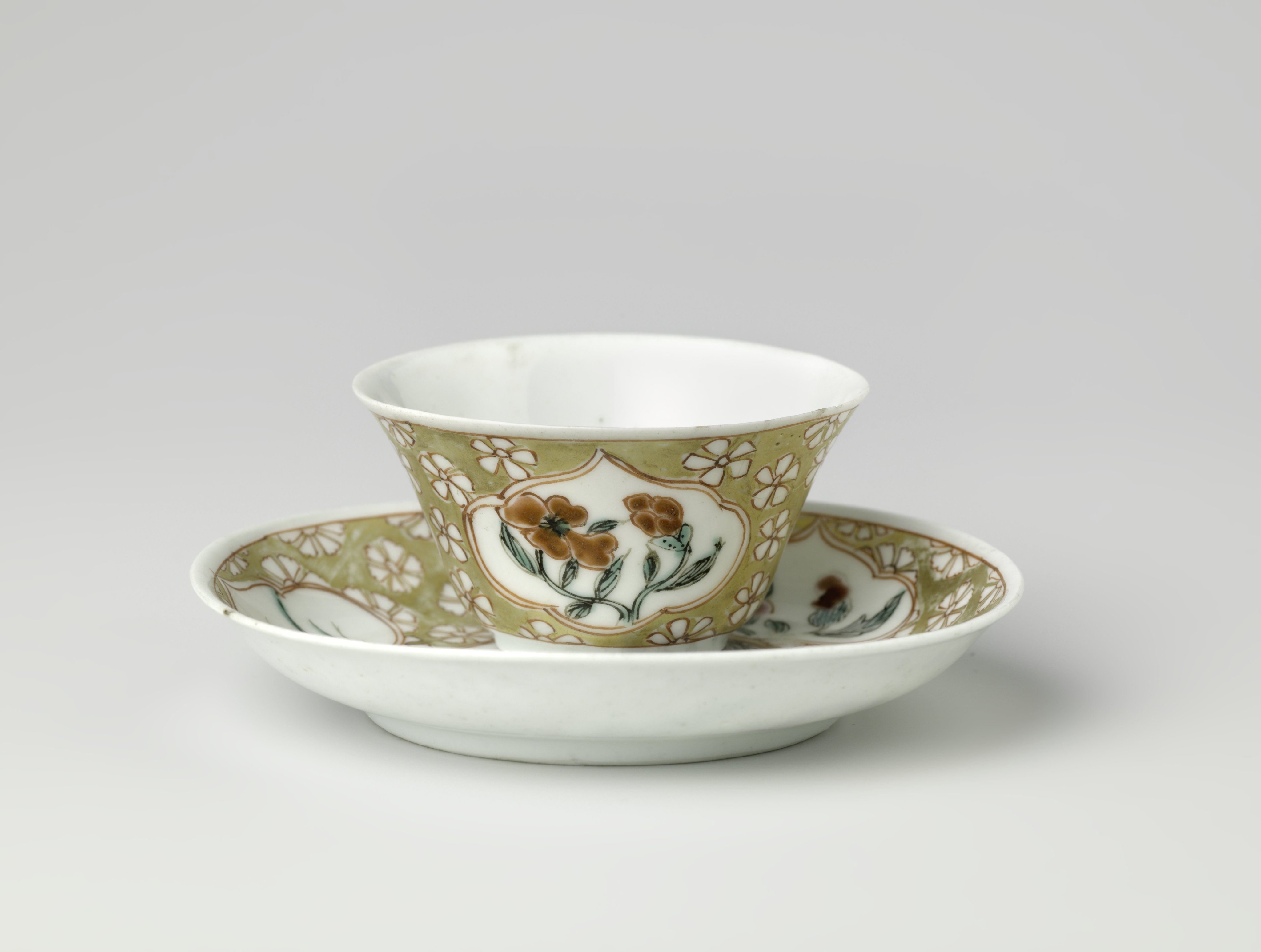 Cup and saucer with a farmer and flowering plants in panels