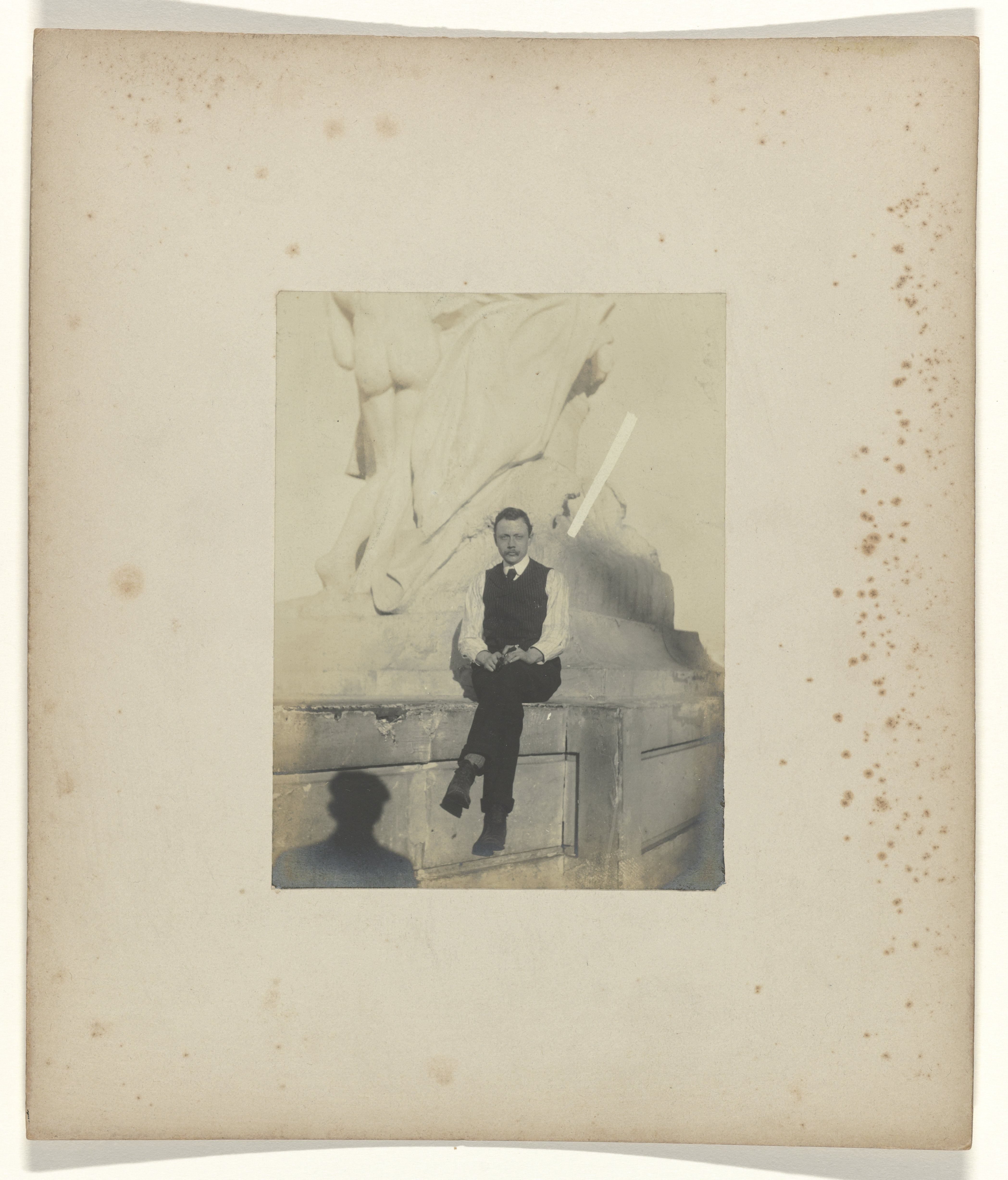 Jan Catharinus Schüller zittend op de sokkel van een beeldhouwwerk op het terrein van de wereldtentoonstelling in St. Louis (Louisiana Purchase Exposition), 1904