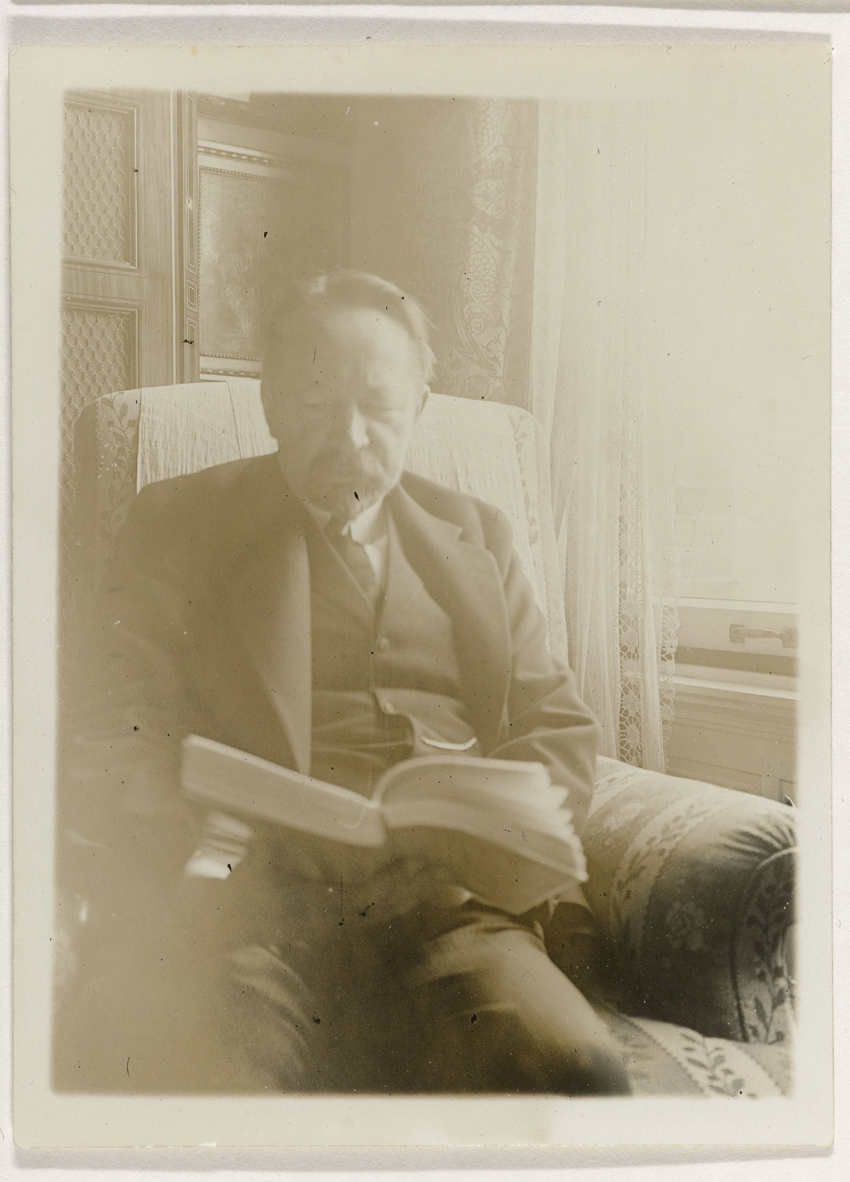 Andries Bonger, in leunstoel, een boek lezend