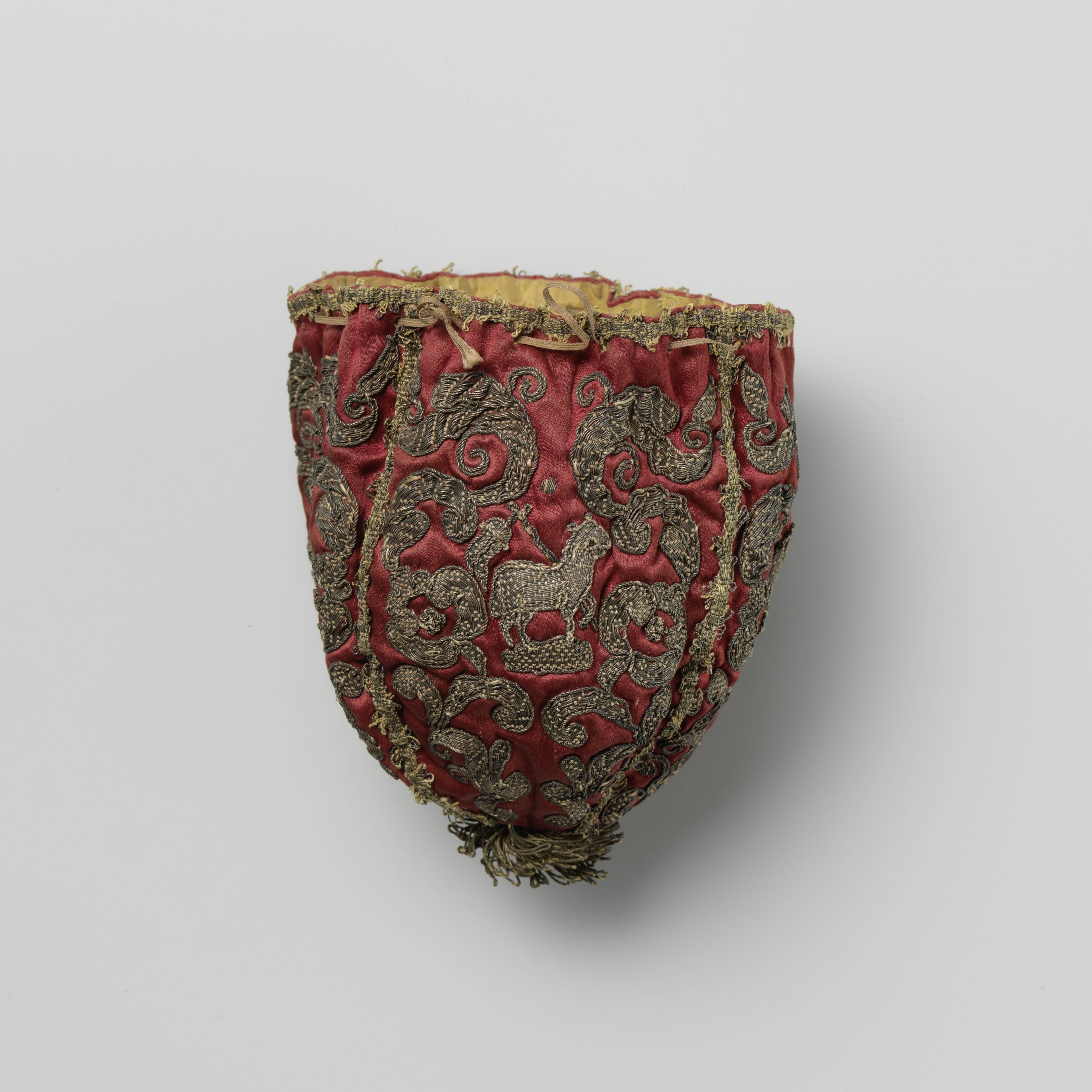 Bursa, donkerrood, versierd met kerkelijke symbolen in opgenaaid gouddraad, o.a. kruisdragend Lam Gods