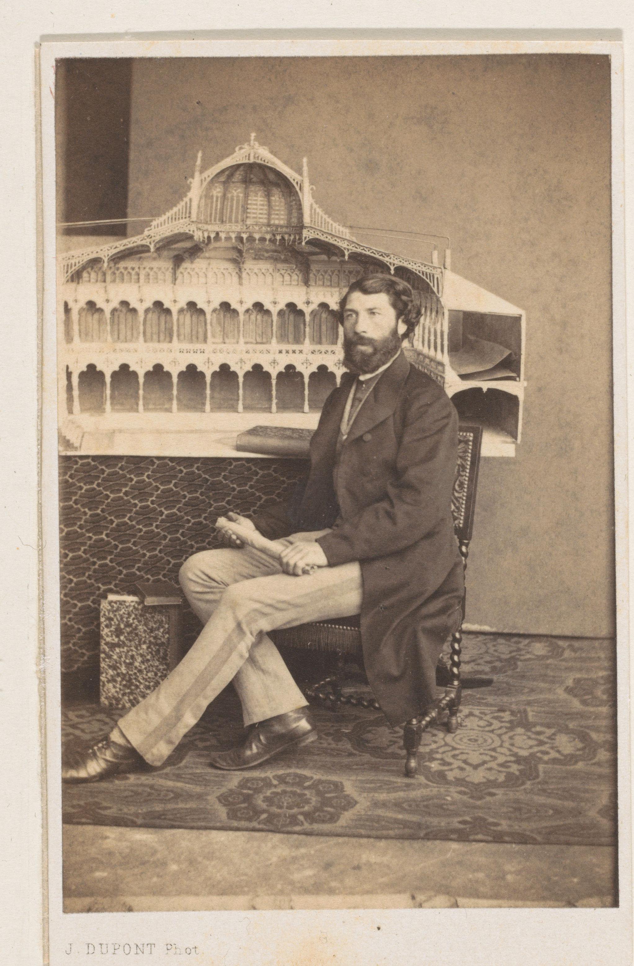 Portret van de architect Looymans, ten voeten uit, met een maquette van de door hem ontworpen Beurs van Antwerpen