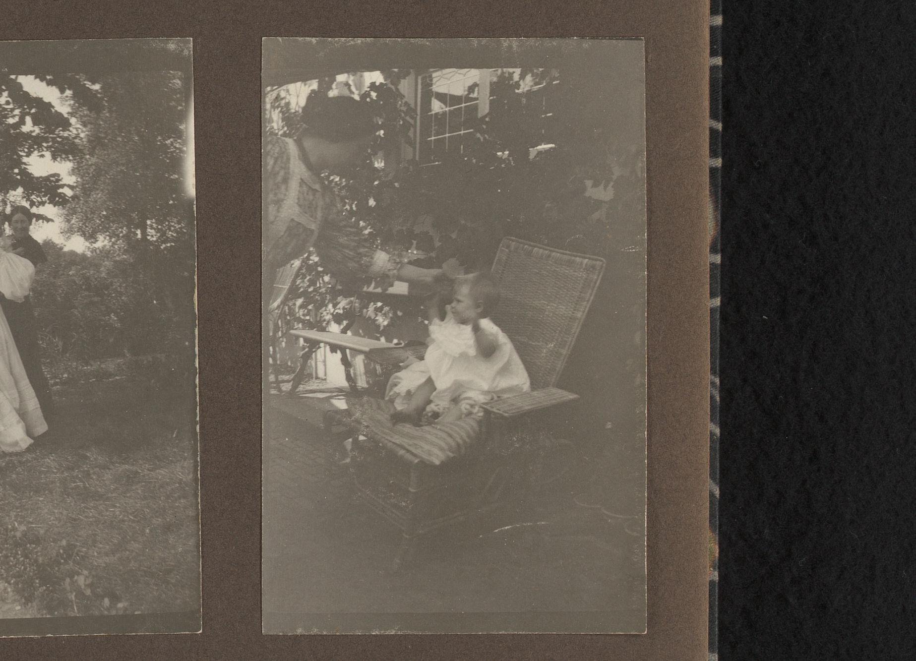 Peuter in een tuinstoel met een vrouw ernaast, vermoedelijk Thea en Elsa Diepenbrock, in Villa de Hoeve in Laren