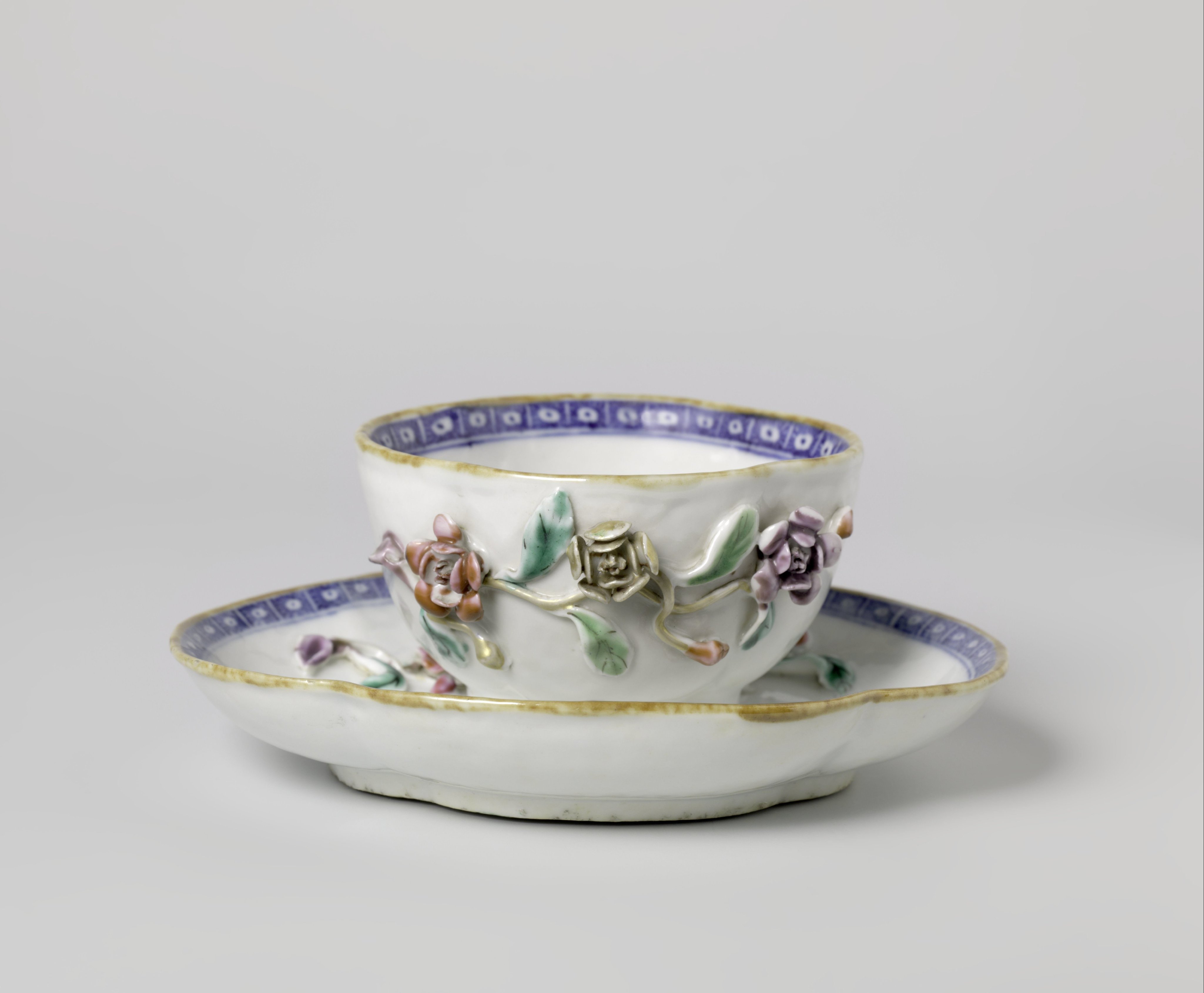 Oval, four-lobed cup and saucer with moulded flower sprays