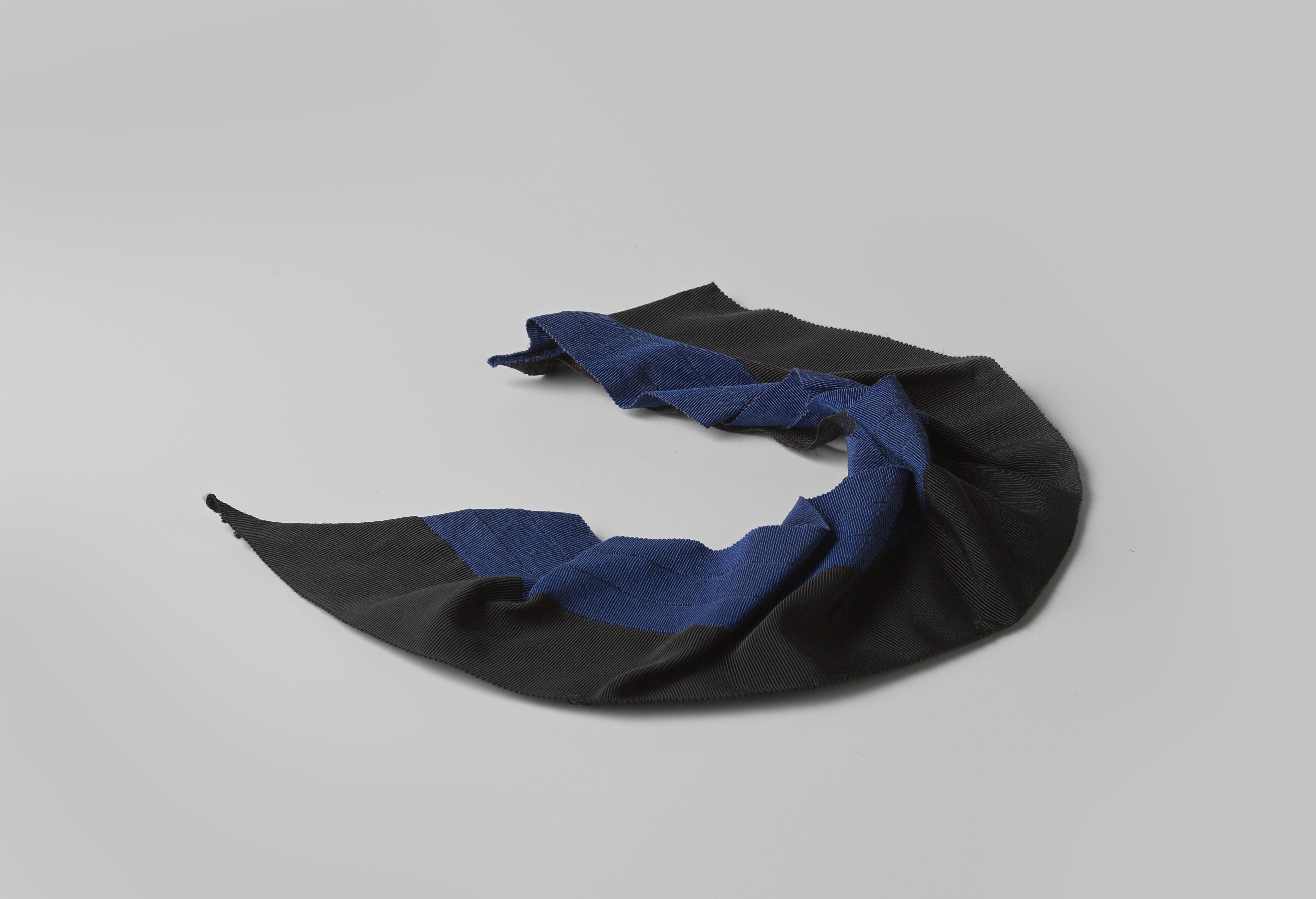 Losse ceintuur van blauwe crêpe, met zwarte knoop te sluiten met een zwarte tres