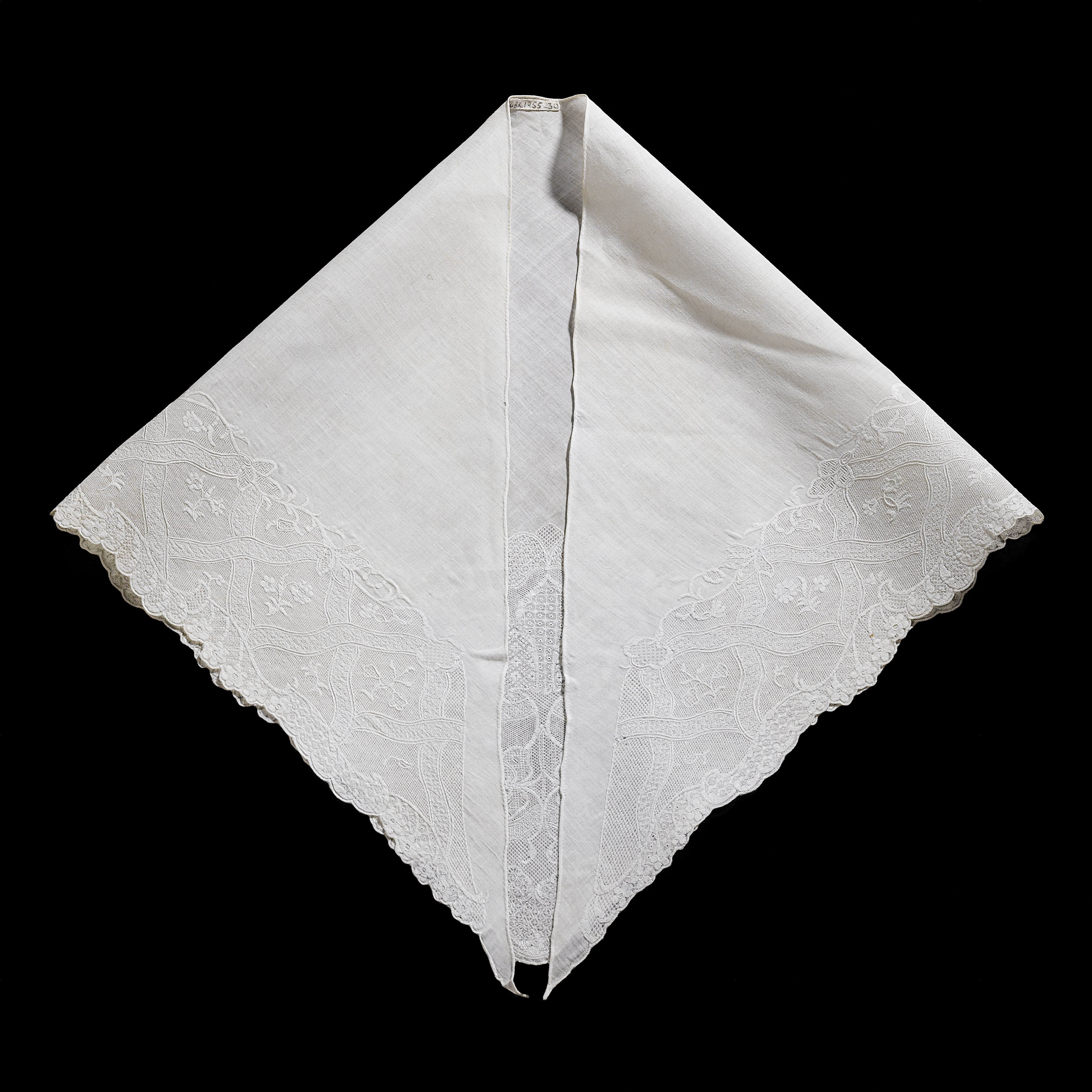 Fichu van linnenbatist, driehoekig en geschulpt, versierd met brede rand van ruiten waarbinnen strooiboeket in tamboereerwerk, schaduwwerk en naaldkant