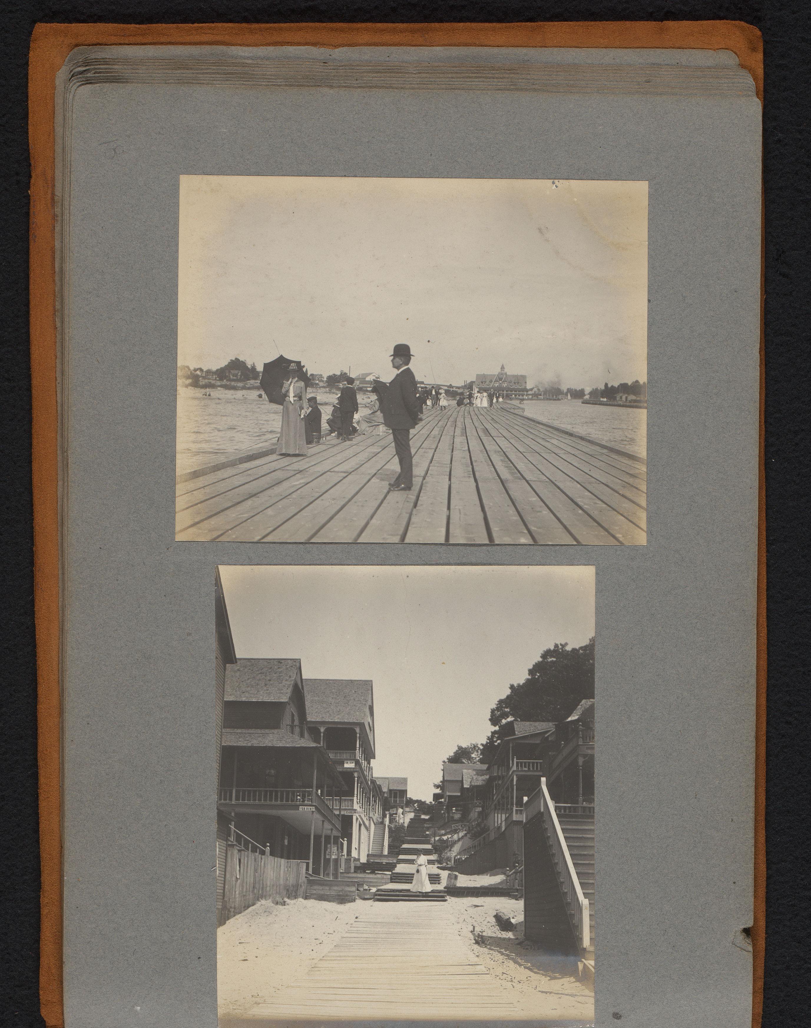 Vissende en wandelende mensen op een pier en een houten pad tussen strandhuizen