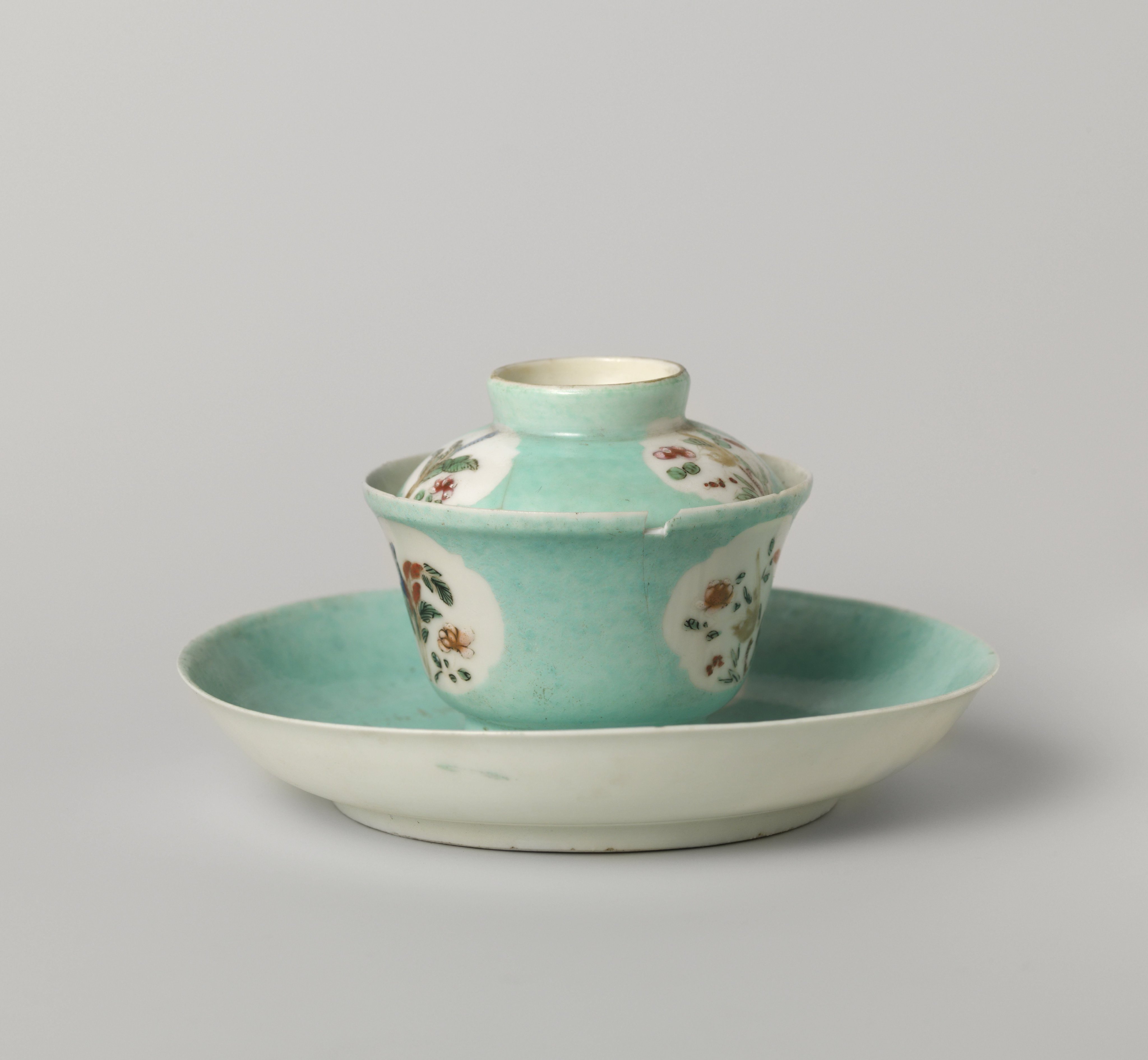 Bell-shaped covered cup and saucer with flowering plants in shaped panels