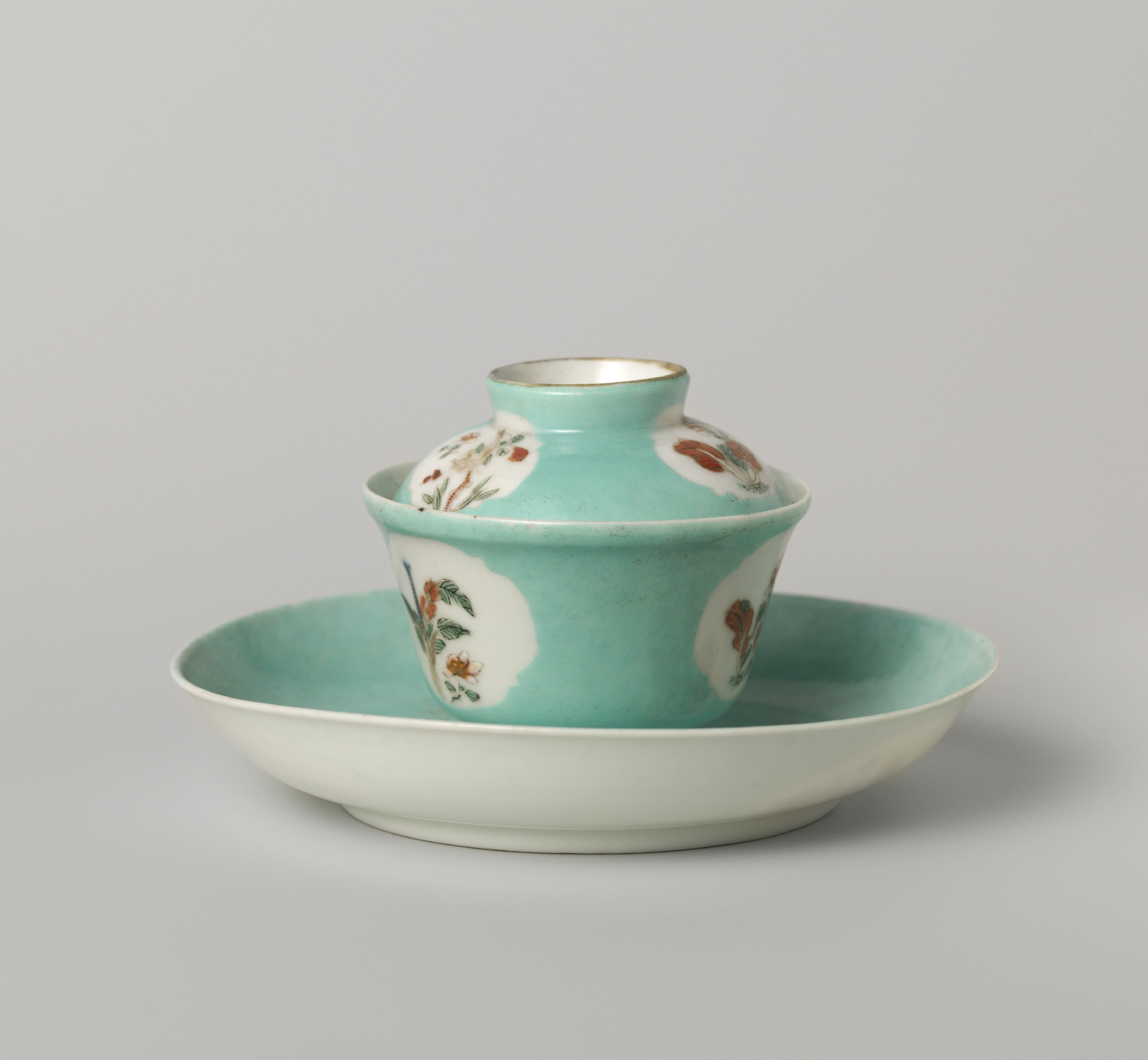 Bell-shaped covered cup and saucer with flowering plants in shaped panels