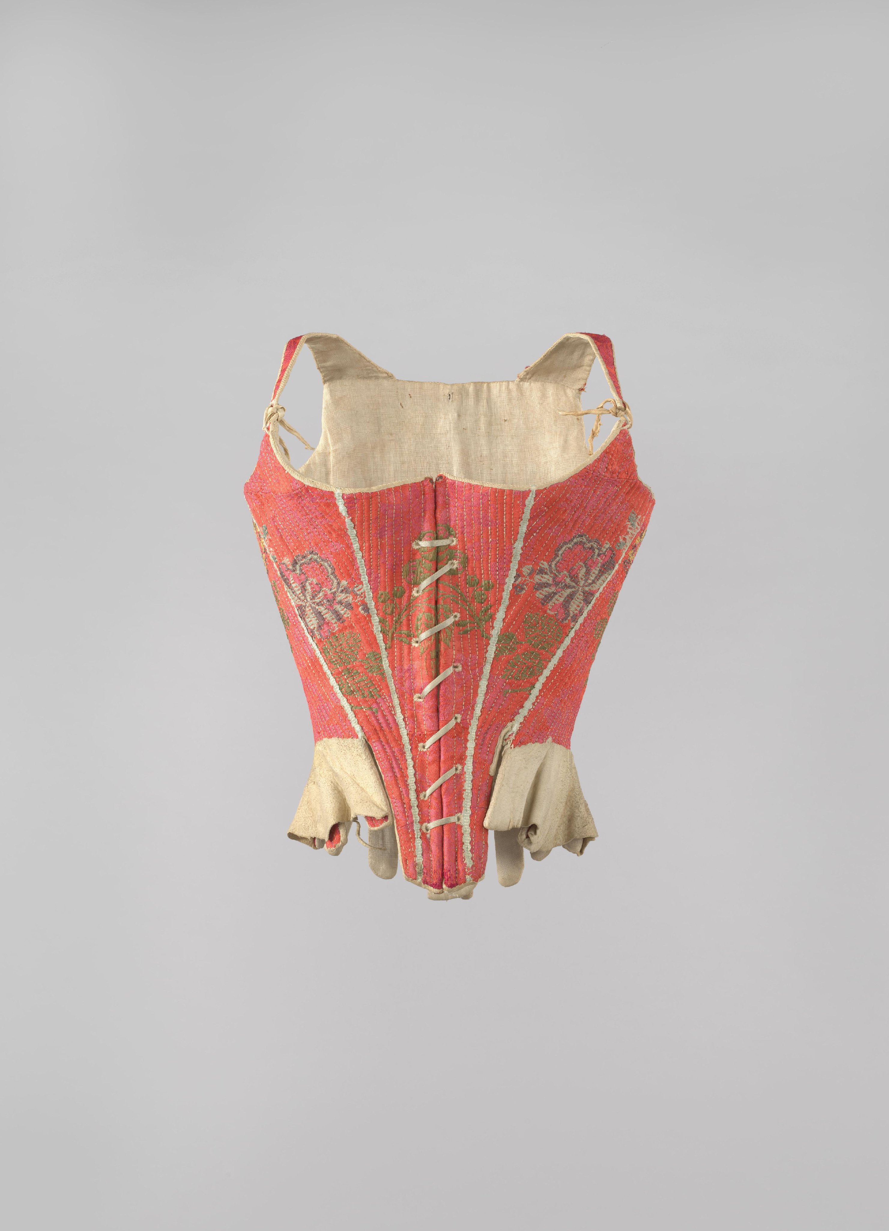Corset overtrokken met een ceriserood wollen weefsel, versierd met polychrome bloemen en wit passement langs vijf rugnaden en vier voornaden.