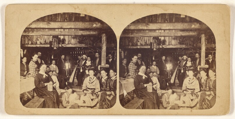 [Large group of people posed in a barn]