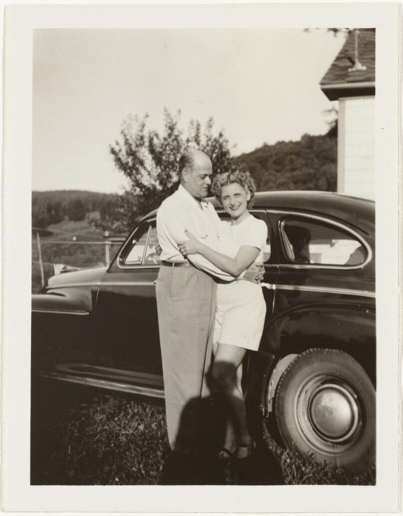 [Man and woman posing by car]