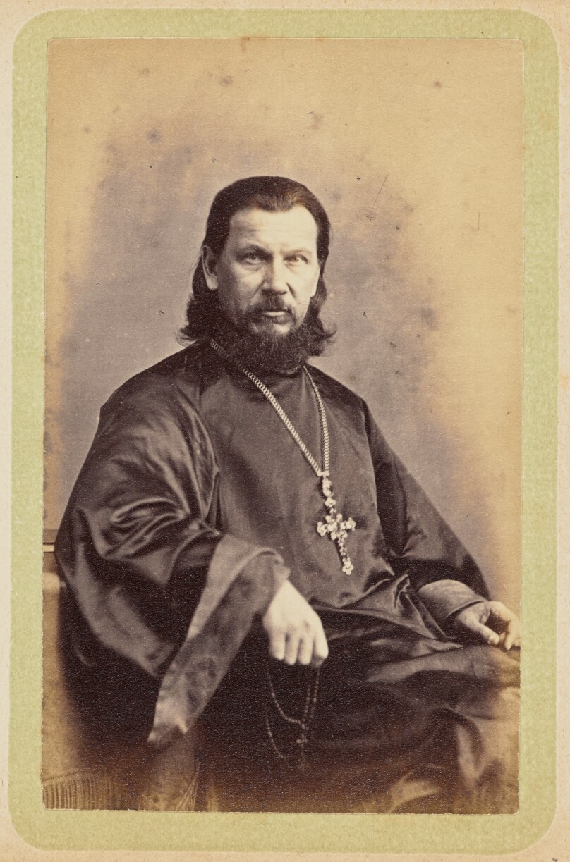 [Man wearing dark robes and a pectoral cross]