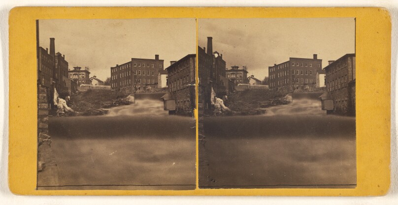 [View of unidentified town with stream at center]
