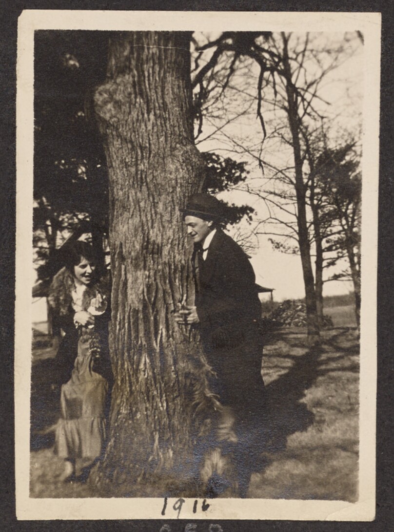 [Man and woman next to a tree]